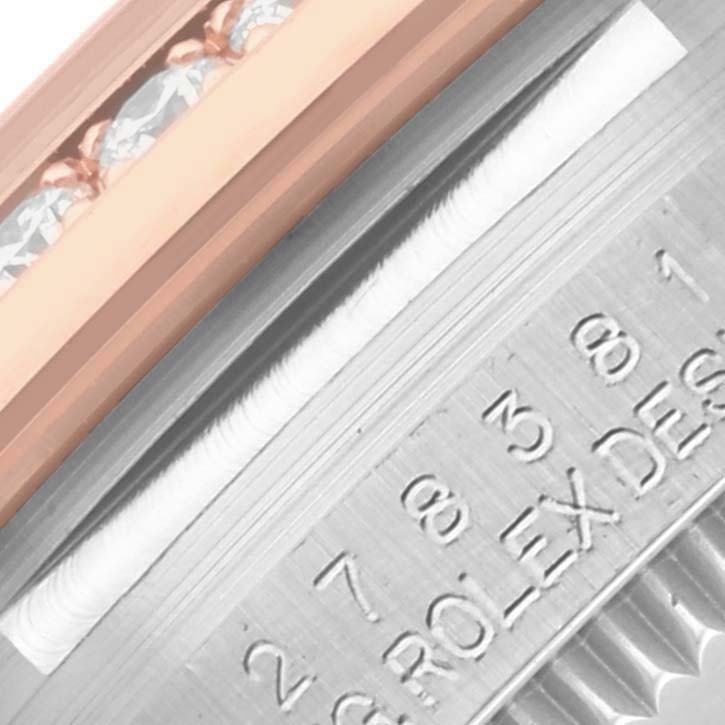 The image shows a close-up of the bezel
s edge and engraving on the Mid-Size Rolex model.