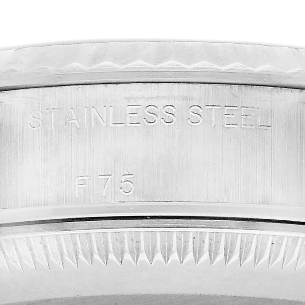 The image shows a close-up of the Rolex Datejust 79174 Women's Stainless Steel Black Dial 79174 Women's Stainless Steel Black Dial watch, highlighting the engraved stainless steel case with visible markings.