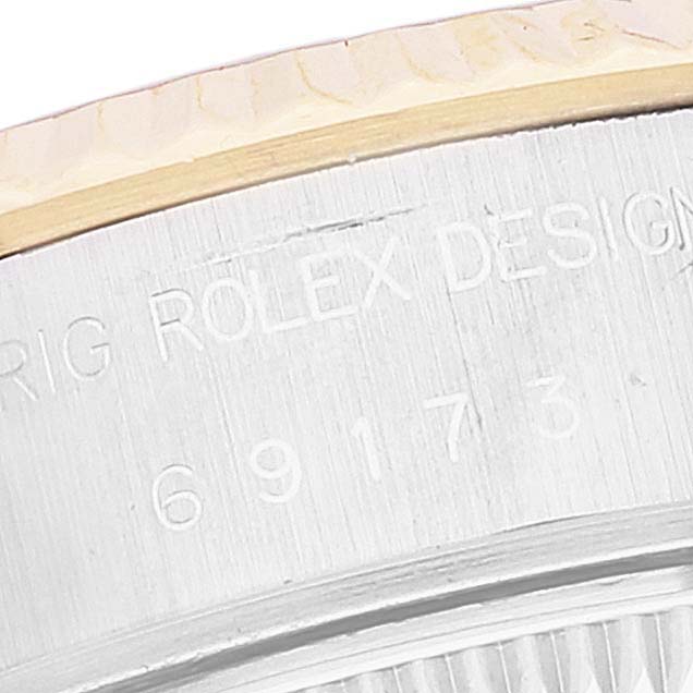 This close-up image shows the engraved serial and design numbers on the side of the bezel of a Rolex Datejust 69173 Women's Steel and Gold (two tone) Champagne Dial 69173 Women's Steel and Gold (two tone) Champagne Dial watch.