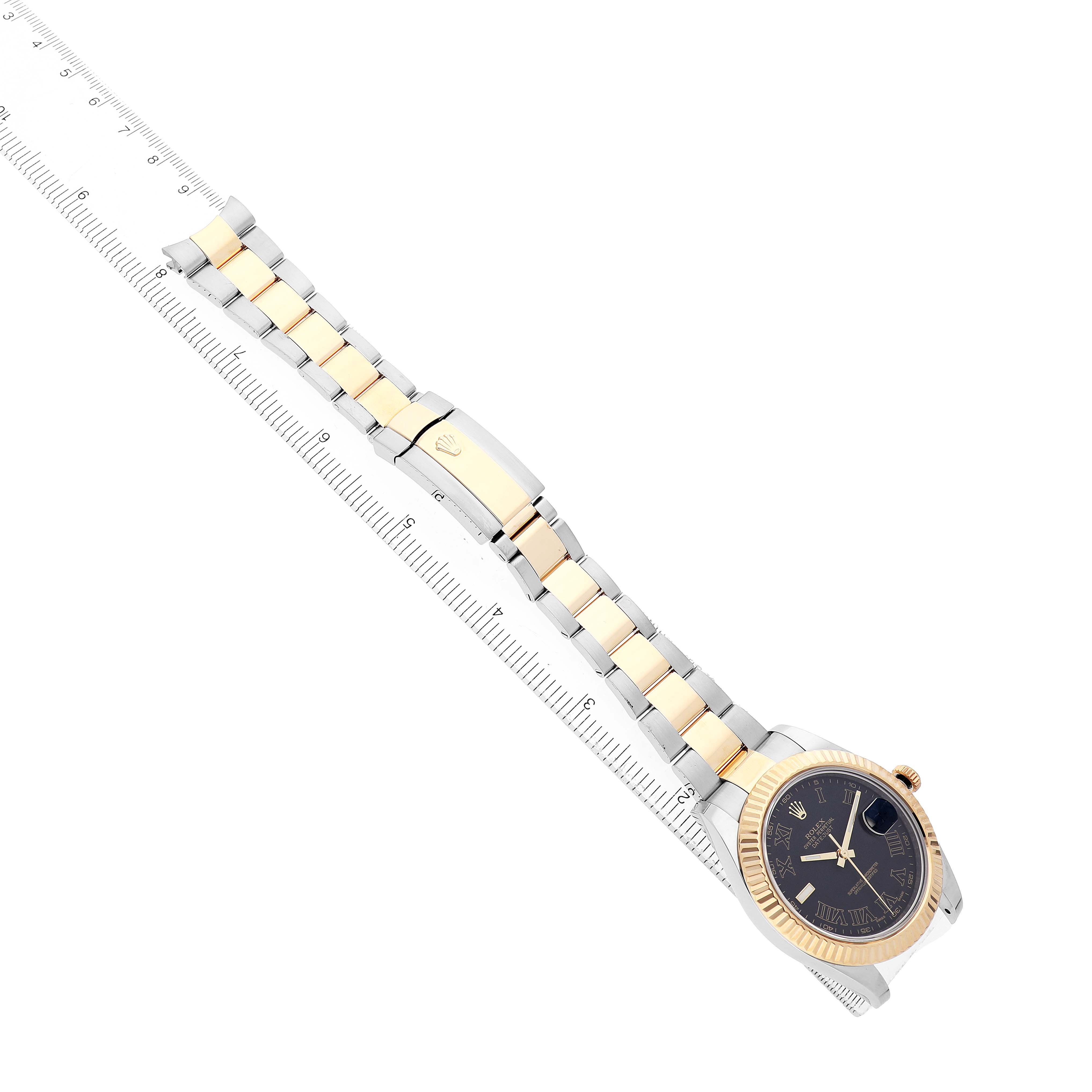 The Rolex Datejust 41 116333 Men's Steel and Gold (two tone) Black Dial is shown from a top-down angle, highlighting its two-tone bracelet, clasp, and dial next to a ruler.
