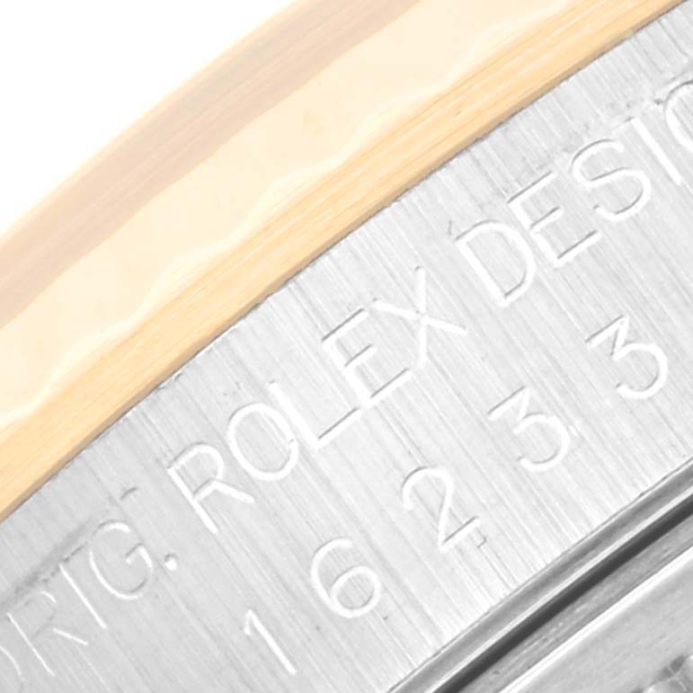 This close-up image of the Rolex Datejust 16233 Men's Steel and Gold (two tone) Grey Dial 16233 Men's Steel and Gold (two tone) Grey Dial watch shows the engraved inner bezel.