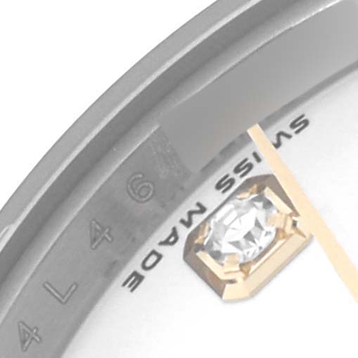 The image shows a close-up of a Rolex Datejust 179173 Women
s Steel and Gold (two tone) White Dial 179173 Women
s Steel and Gold (two tone) White Dial watch face, highlighting parts of the dial, bezel, and a diamond hour marker.