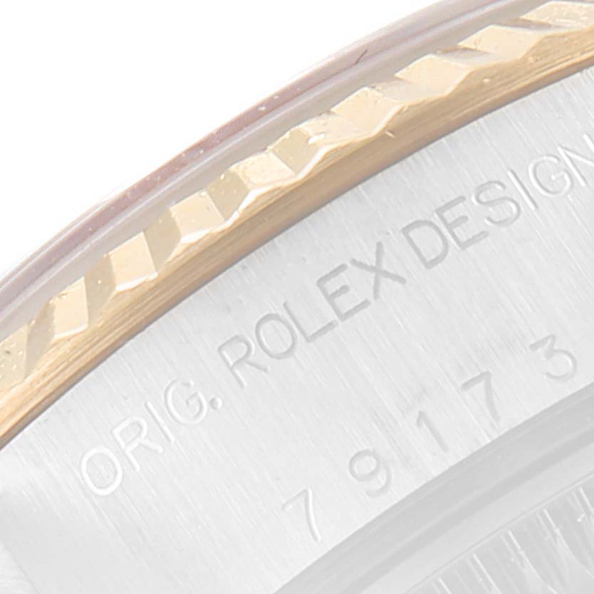 This image shows a close-up angle of the engraved bezel and caseback edge of a Rolex Datejust 79173 Women's Steel and Gold (two tone) White Dial 79173 Women's Steel and Gold (two tone) White Dial watch.