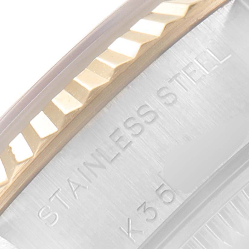 This image shows a close-up of the fluted bezel and part of the case of a Rolex Datejust 79173 Women's Steel and Gold (two tone) White Dial 79173 Women's Steel and Gold (two tone) White Dial watch, with "STAINLESS STEEL" engraved.