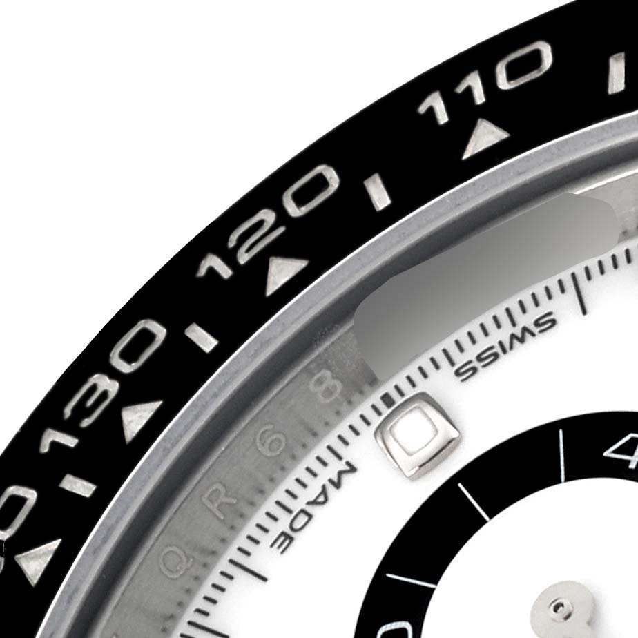 The image shows a close-up of the bezel and part of the dial of a Rolex Daytona 116500LN Men's Stainless Steel White Dial 116500LN Men's Stainless Steel White Dial watch.