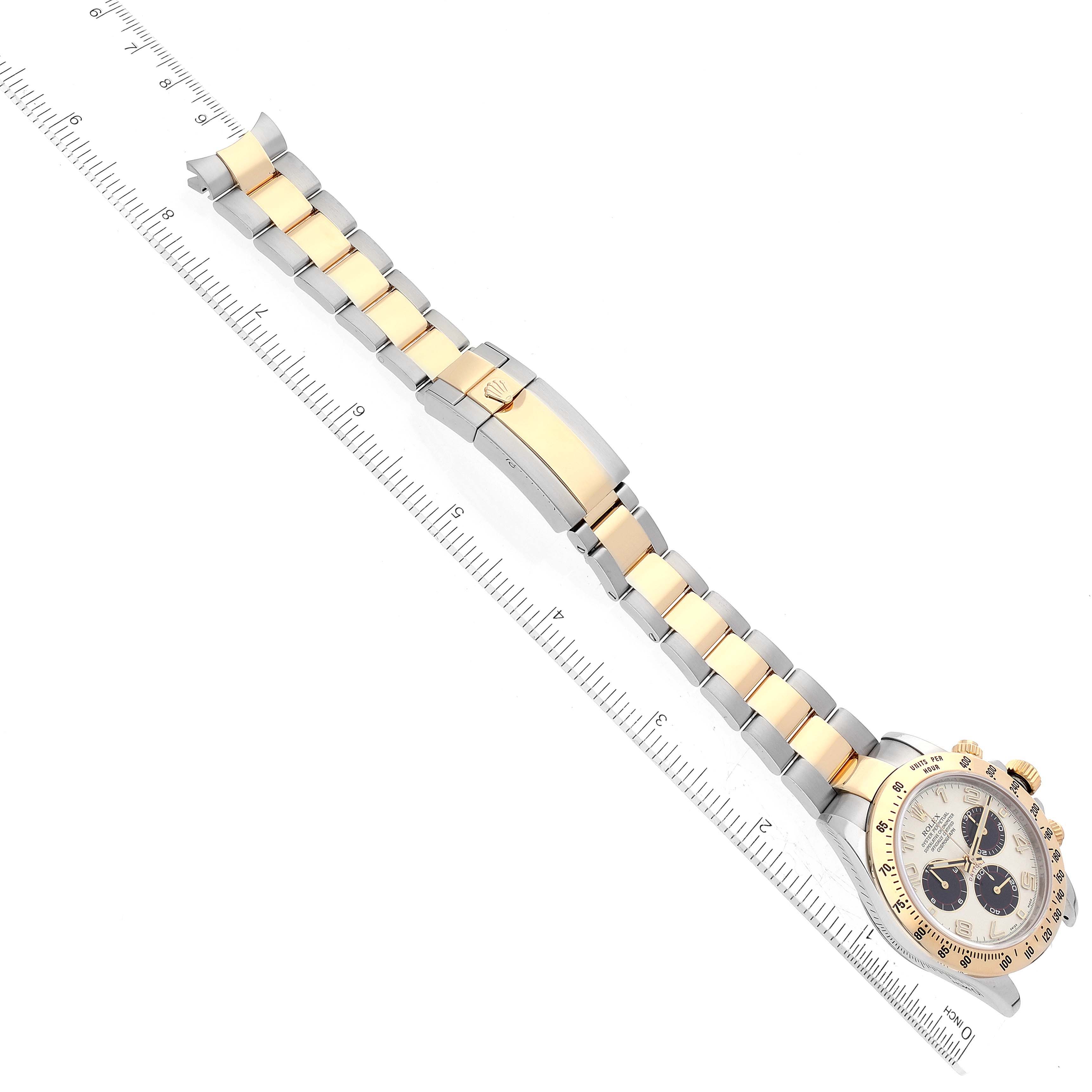 The image shows a Rolex Daytona 116523 Men's Steel and Gold (two tone) Silver Dial 116523 Men's Steel and Gold (two tone) Silver Dial watch laid flat with its face and two-tone bracelet fully visible, alongside a ruler for scale.
