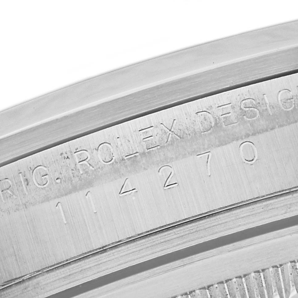 This close-up image shows the engraved serial number and "Rolex Design" text on the side of the Rolex Explorer 114270 Men's Stainless Steel Black Dial 114270 Men's Stainless Steel Black Dial watch case.