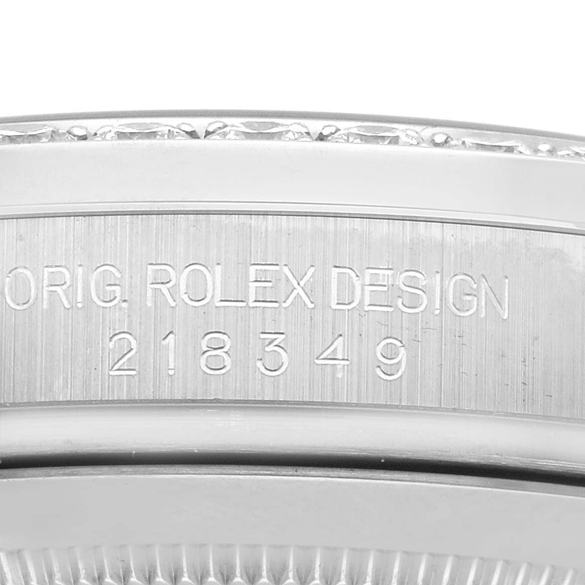 This image shows a close-up of the edge of a Rolex President 218349 Men's White Gold Silver Dial 218349 Men's White Gold Silver Dial model case with engraved model details.