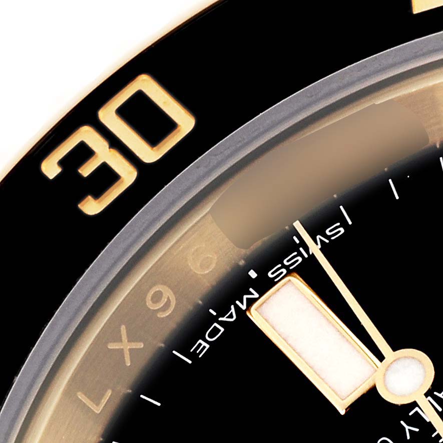 The image shows a close-up of the Rolex Submariner 116618LN Men's Yellow Gold Black Dial 116618LN Men's Yellow Gold Black Dial's bezel and part of the dial with the "Swiss Made" text.