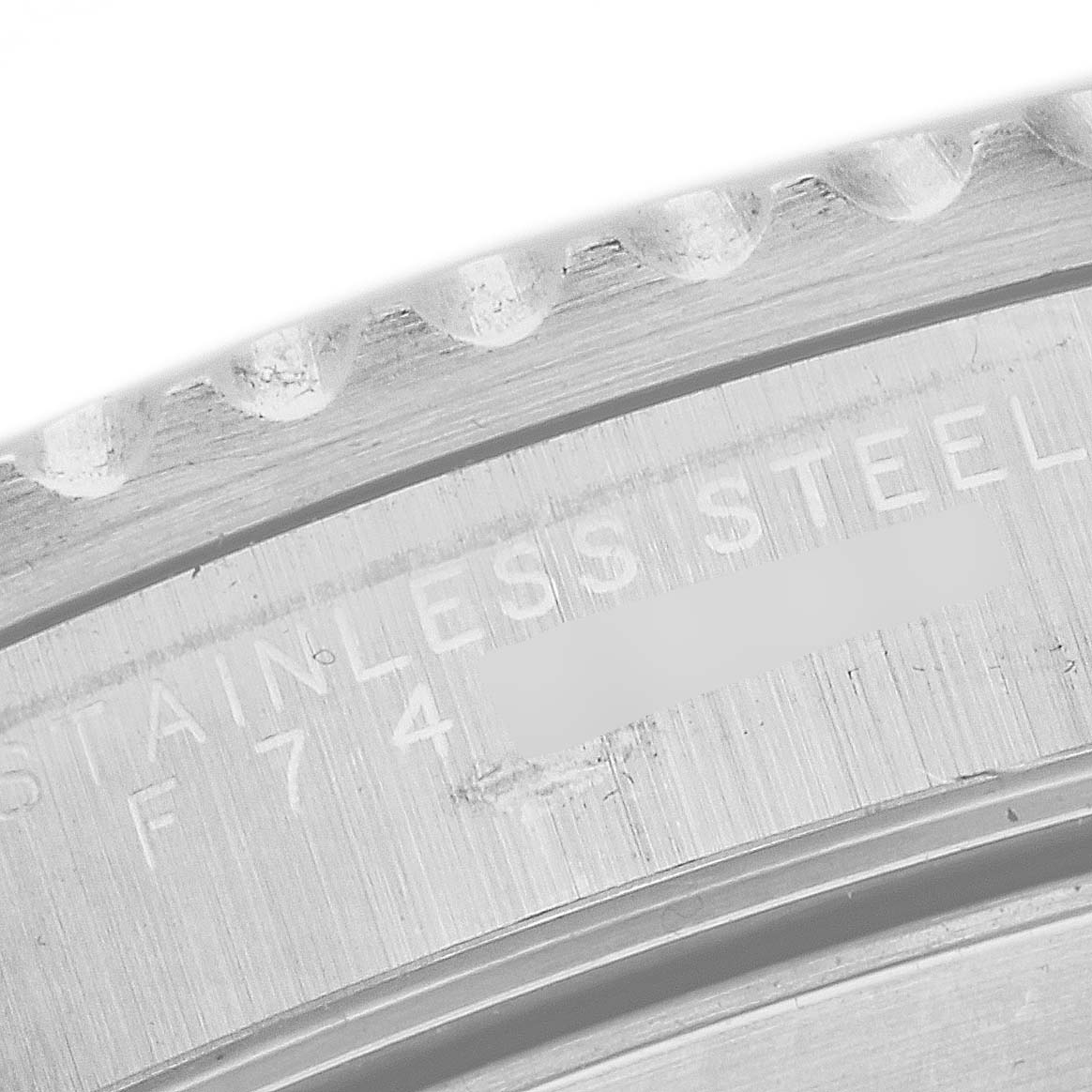 The image shows a close-up of the side of a stainless steel Rolex Submariner 14060M Men
s Stainless Steel Black Dial 14060M Men
s Stainless Steel Black Dial watch case, revealing part of the bezel and engraved text.