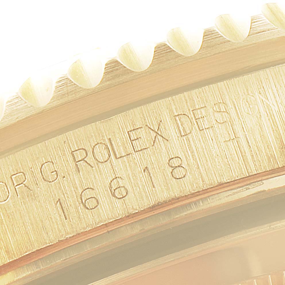 This image shows a close-up of the case side of a Rolex Submariner 16618 Men
s Yellow Gold Blue Dial 16618 Men
s Yellow Gold Blue Dial, highlighting the model number and part of the bezel.