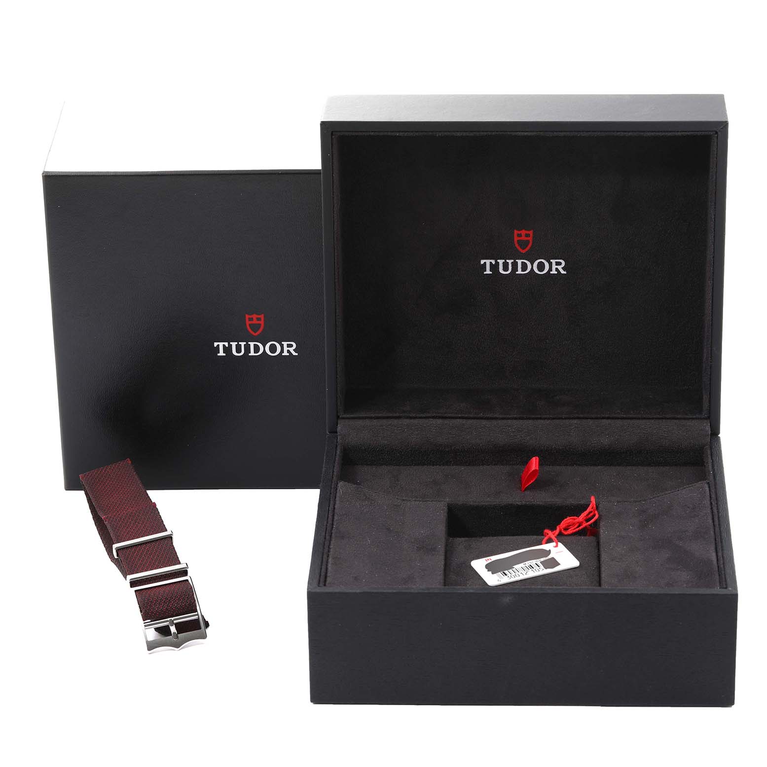 The image shows the packaging for a Tudor Heritage Black Bay 79230R Men
s Stainless Steel Black Dial 79230R Men
s Stainless Steel Black Dial watch, including an additional strap and the watch box.