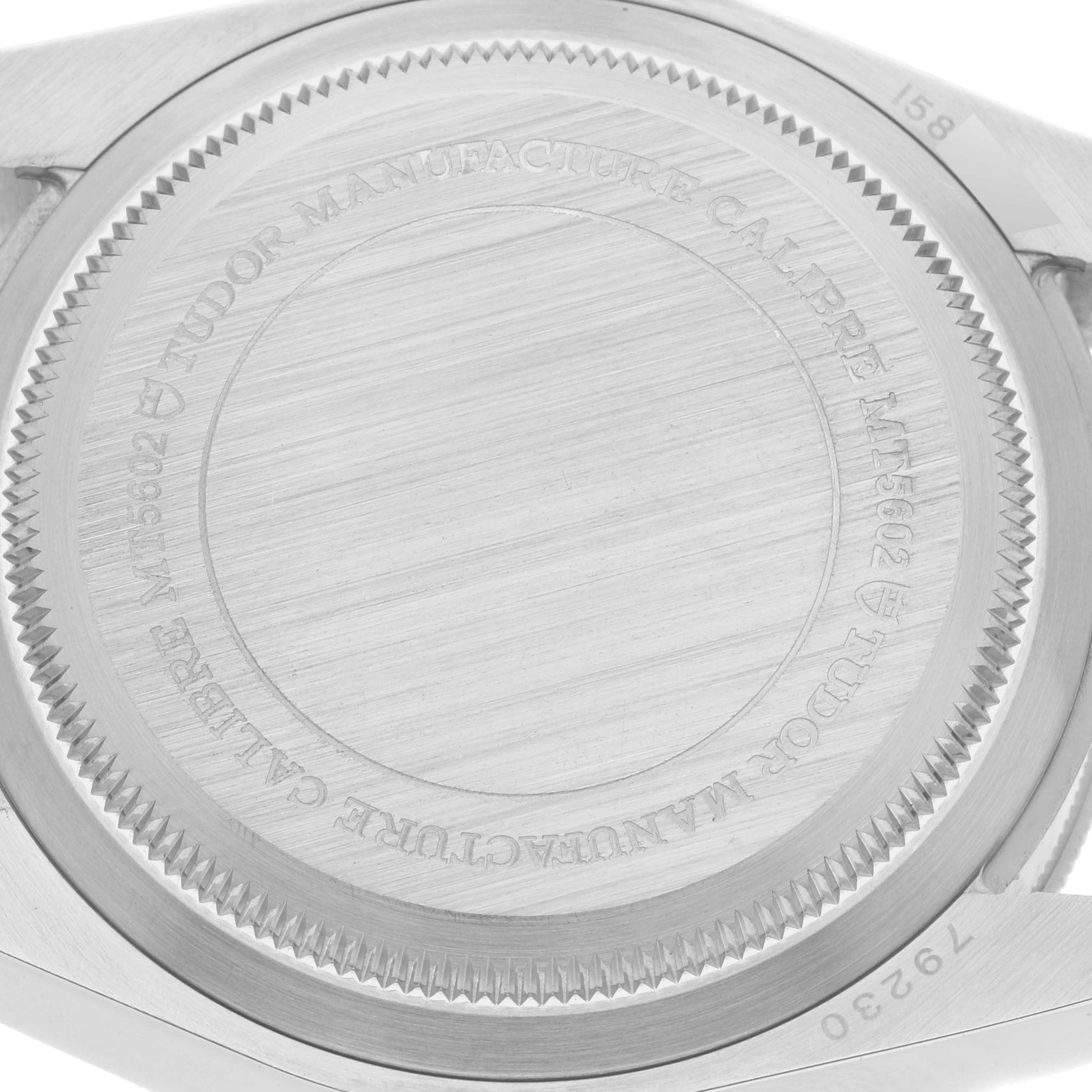 The image shows a close-up of the case back of the Tudor Heritage Black Bay 79230R Men
s Stainless Steel Black Dial 79230R Men
s Stainless Steel Black Dial watch, displaying its engravings and brushed finish.