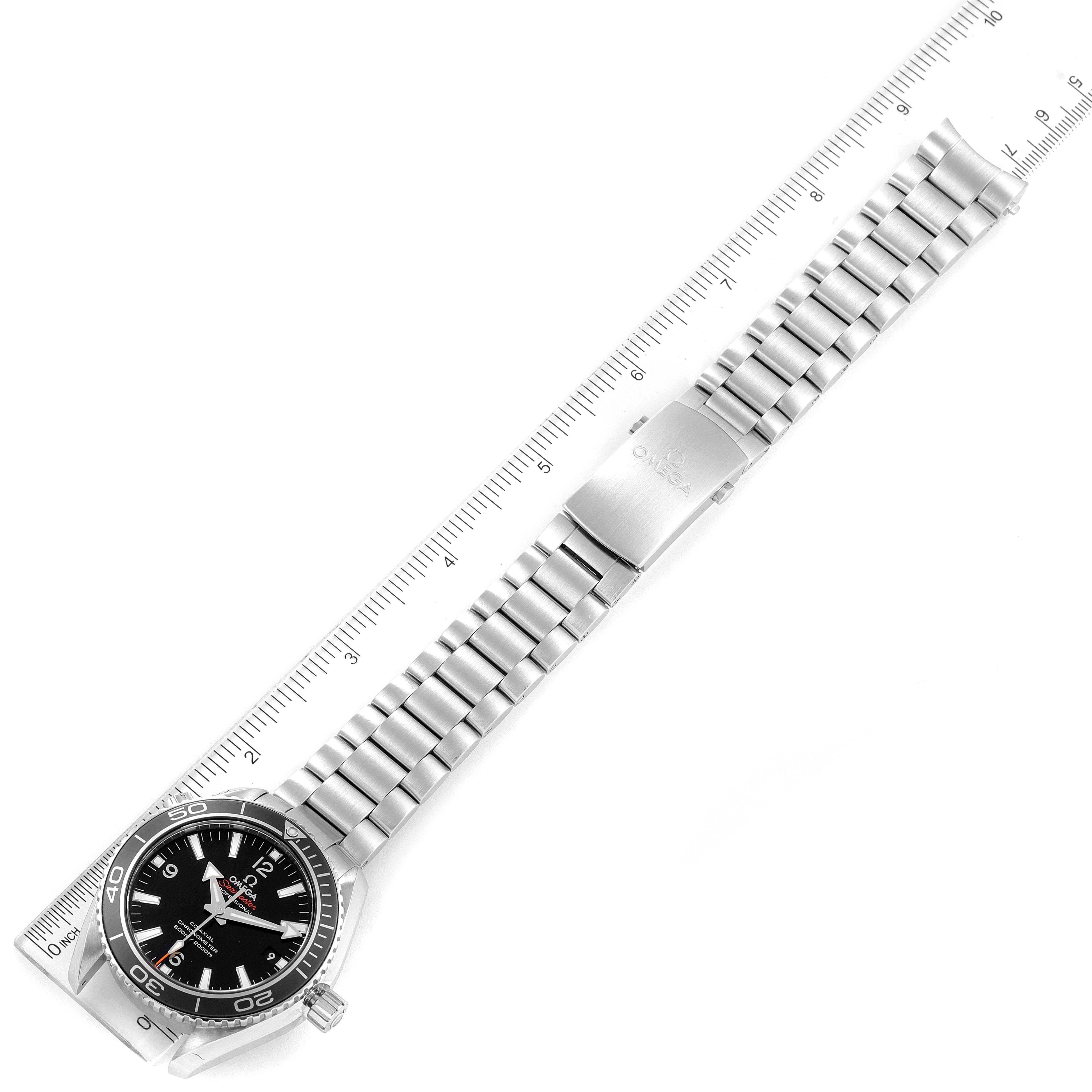 The Omega Planet Ocean 232.30.42.21.01.003 Men
s Stainless Steel Black Dial 232.30.42.21.01.003 Men
s Stainless Steel Black Dial watch is shown from a top-down angle, featuring its full bracelet and bezel next to a ruler for scale.
