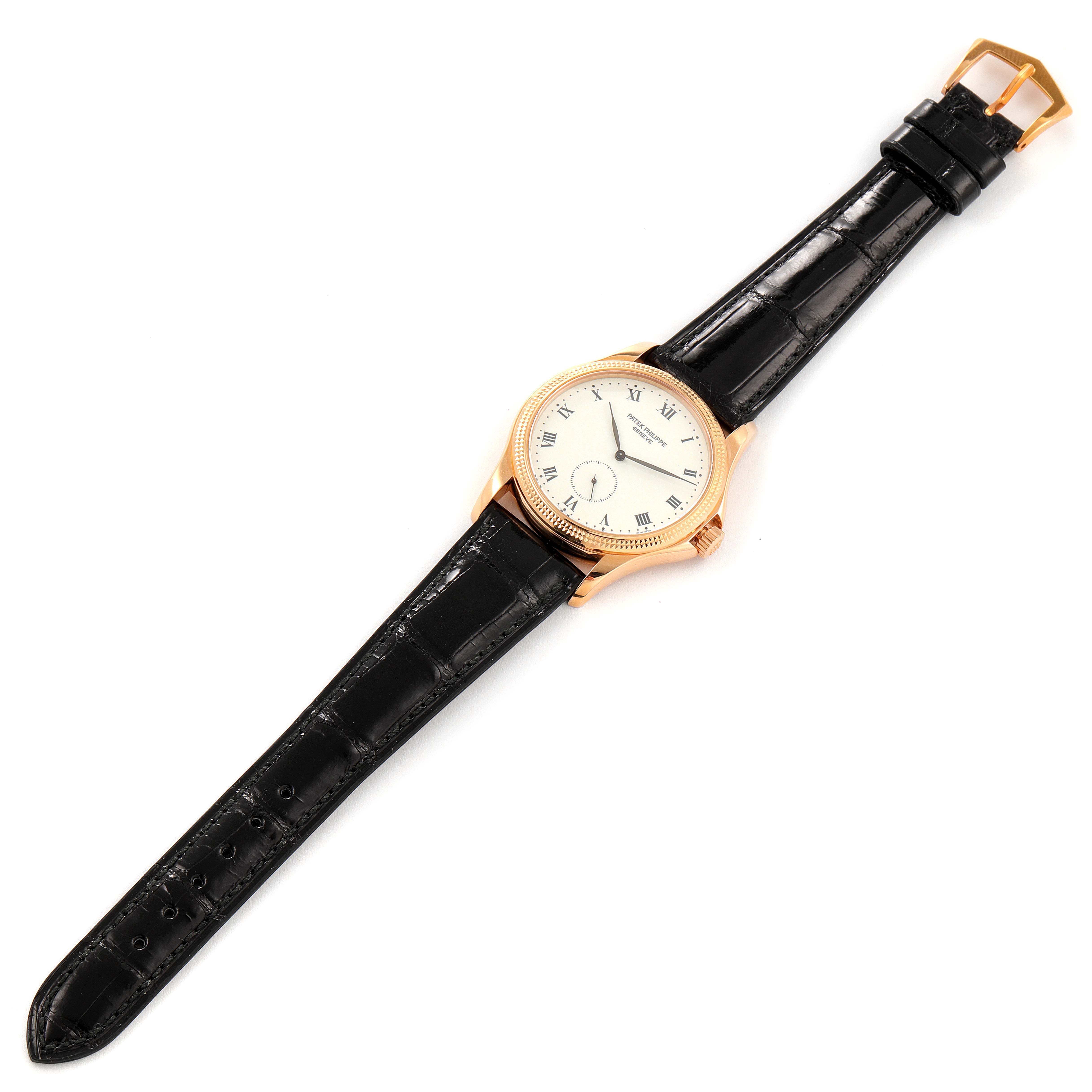 The image shows a top view of a Patek Philippe Calatrava 5115R Men's Rose Gold White Dial 5115R Men's Rose Gold White Dial watch, featuring its dial, hands, and black leather strap.