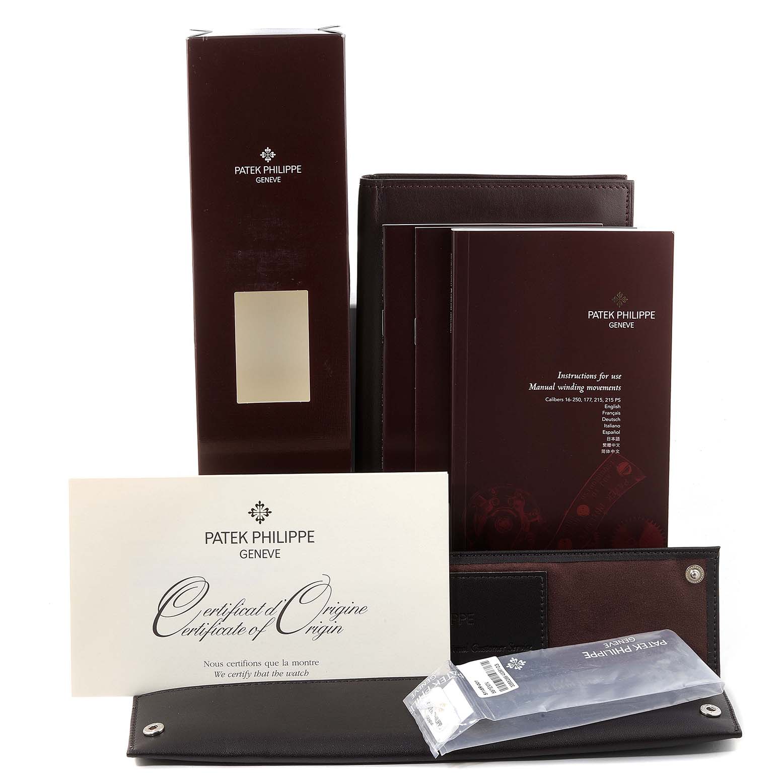 The image shows the packaging, manuals, and certificate of origin for a Patek Philippe Calatrava 5115R Men's Rose Gold White Dial 5115R Men's Rose Gold White Dial model watch.