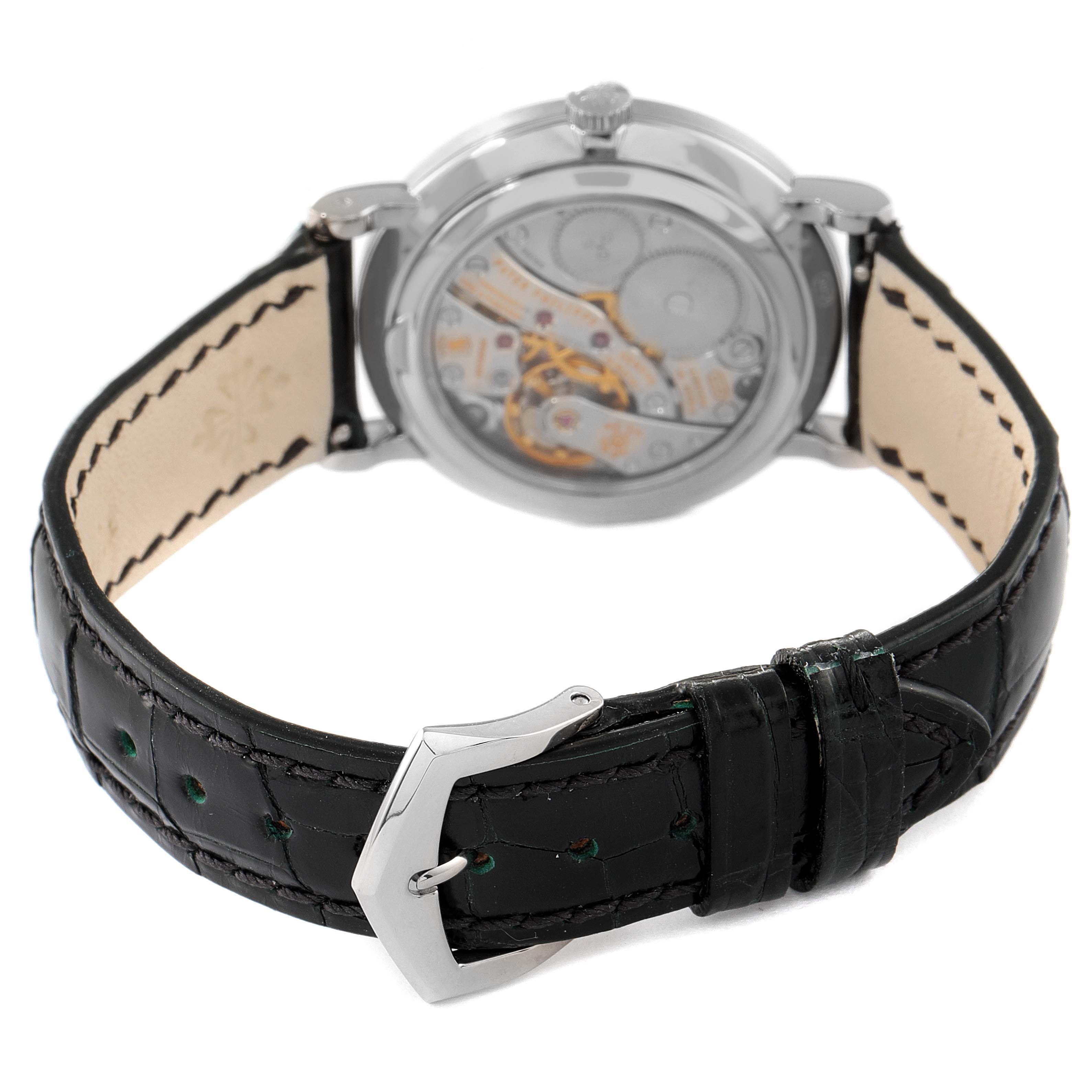 The Patek Philippe Calatrava 7119G Men's White Gold Silver Dial 7119G Men's White Gold Silver Dial watch is shown from the rear, displaying the movement and black leather strap with buckle.