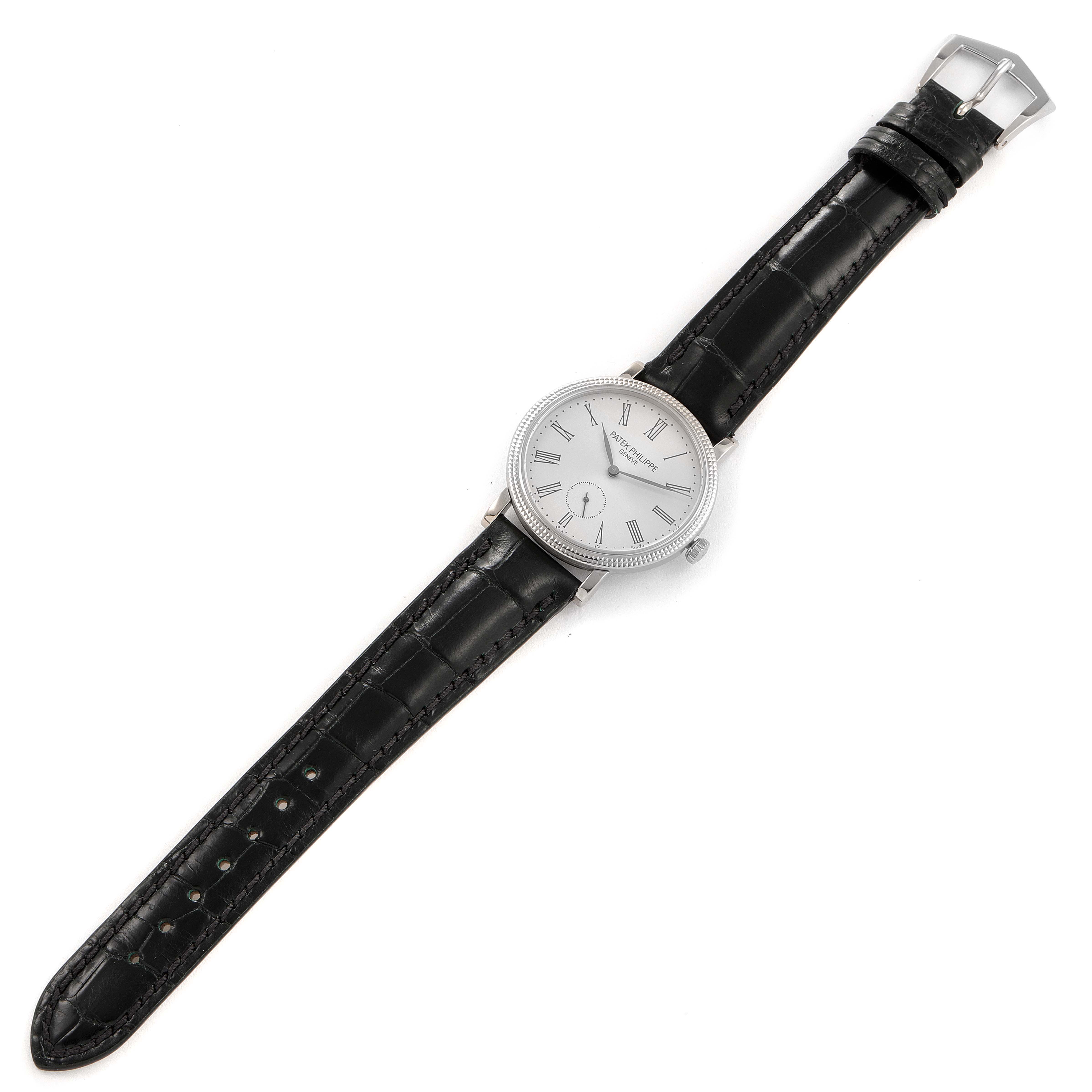 The Patek Philippe Calatrava 7119G Men's White Gold Silver Dial 7119G Men's White Gold Silver Dial watch is shown from a top-down angle, displaying the face, case, and black leather strap.