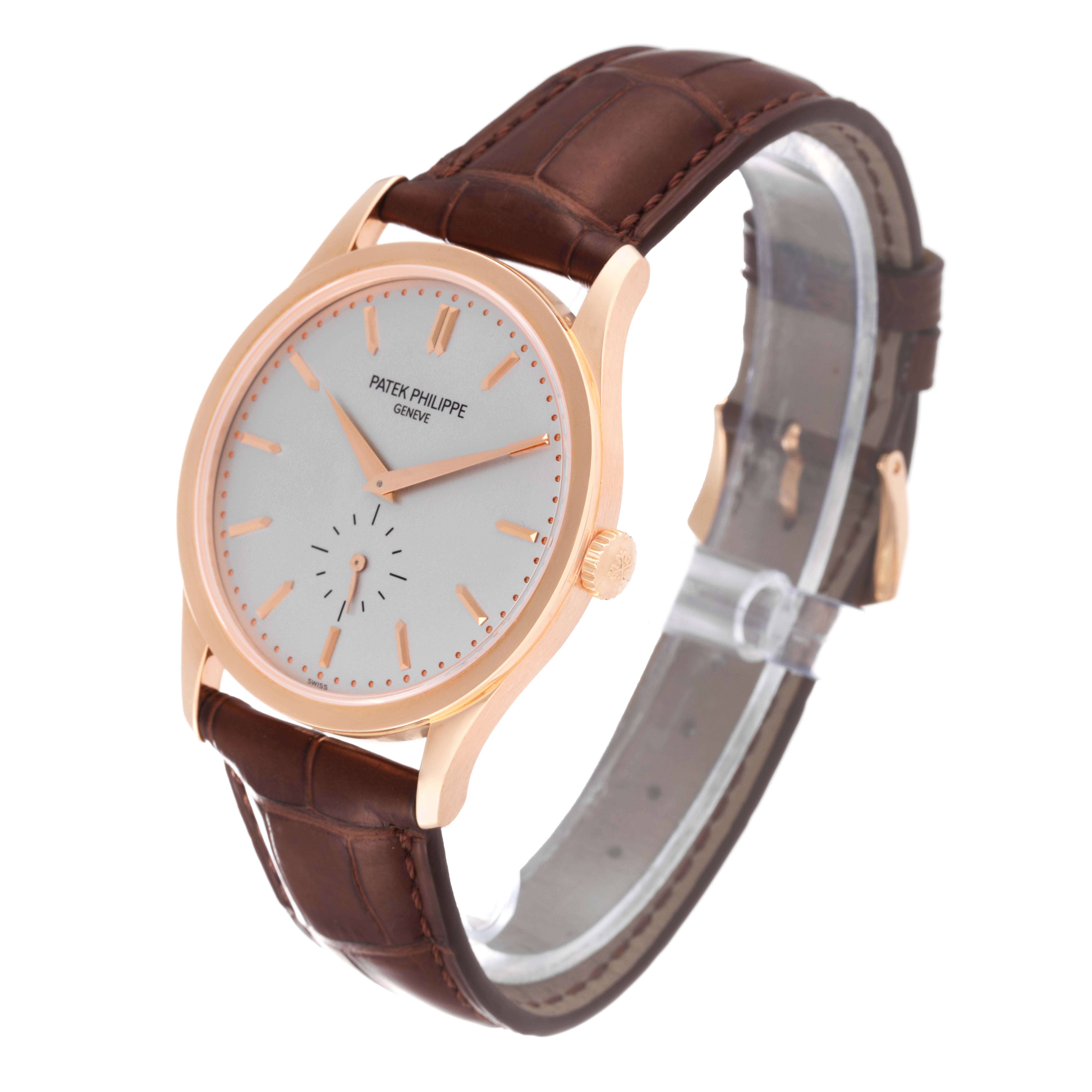 The image shows a Patek Philippe Calatrava 5196R Men
s Rose Gold Silver Dial 5196R Men
s Rose Gold Silver Dial watch angled to display the face, crown, and leather strap.