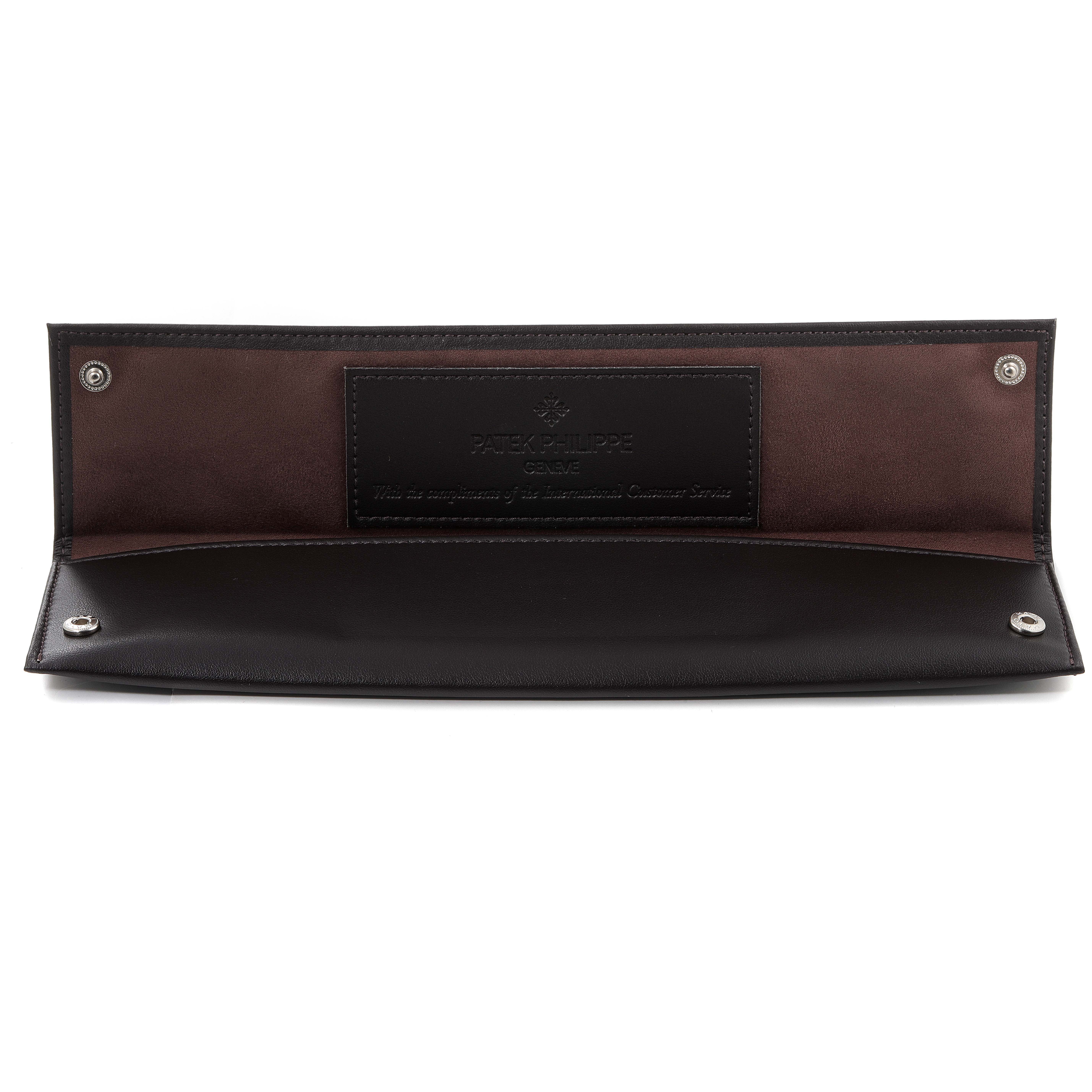 This image shows a brown and black Patek Philippe Calatrava 5119R Men's Rose Gold White Dial 5119R Men's Rose Gold White Dial watch case or pouch, open to display its interior.