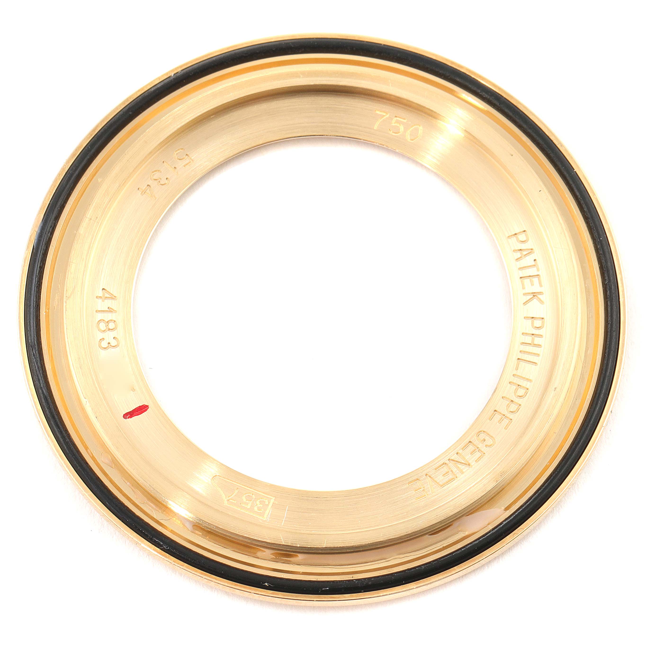 This image shows the rear view of a Patek Philippe Calatrava 5134J Men's Yellow Gold White Dial 5134J Men's Yellow Gold White Dial watch bezel, revealing inner inscriptions and details.