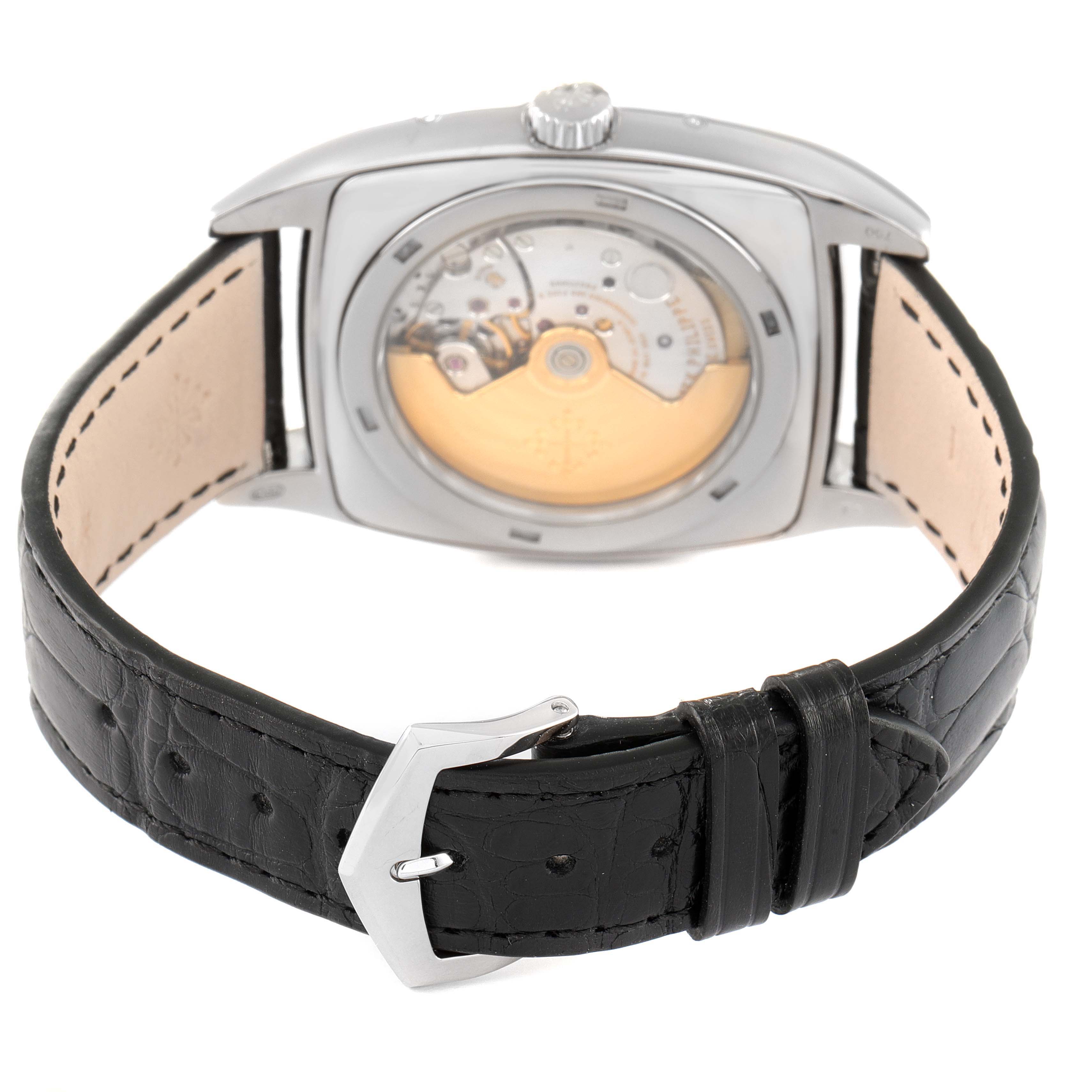 The Patek Philippe Gondolo 5135G Men's White Gold Silver Dial 5135G Men's White Gold Silver Dial watch is shown from the back, displaying the movement mechanism and black leather strap.