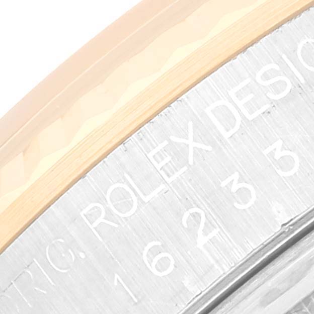 The image shows a close-up of the engraved serial number and the edge of the bezel of a Rolex Datejust 16233 Men's Steel and Gold (two tone) Champagne Dial 16233 Men's Steel and Gold (two tone) Champagne Dial watch.