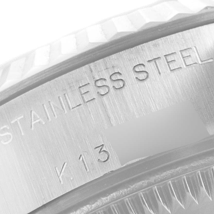 This image shows a close-up of the case back and part of the fluted bezel of a Rolex Datejust 79174 Women
s Stainless Steel White Dial 79174 Women
s Stainless Steel White Dial watch, highlighting "STAINLESS STEEL" engraving.