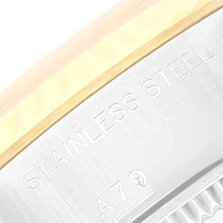 This close-up image shows the side of a Rolex Datejust 79173 Women's Steel and Gold (two tone) Champagne Dial 79173 Women's Steel and Gold (two tone) Champagne Dial watch, highlighting the stainless steel bezel and part of the engraving.
