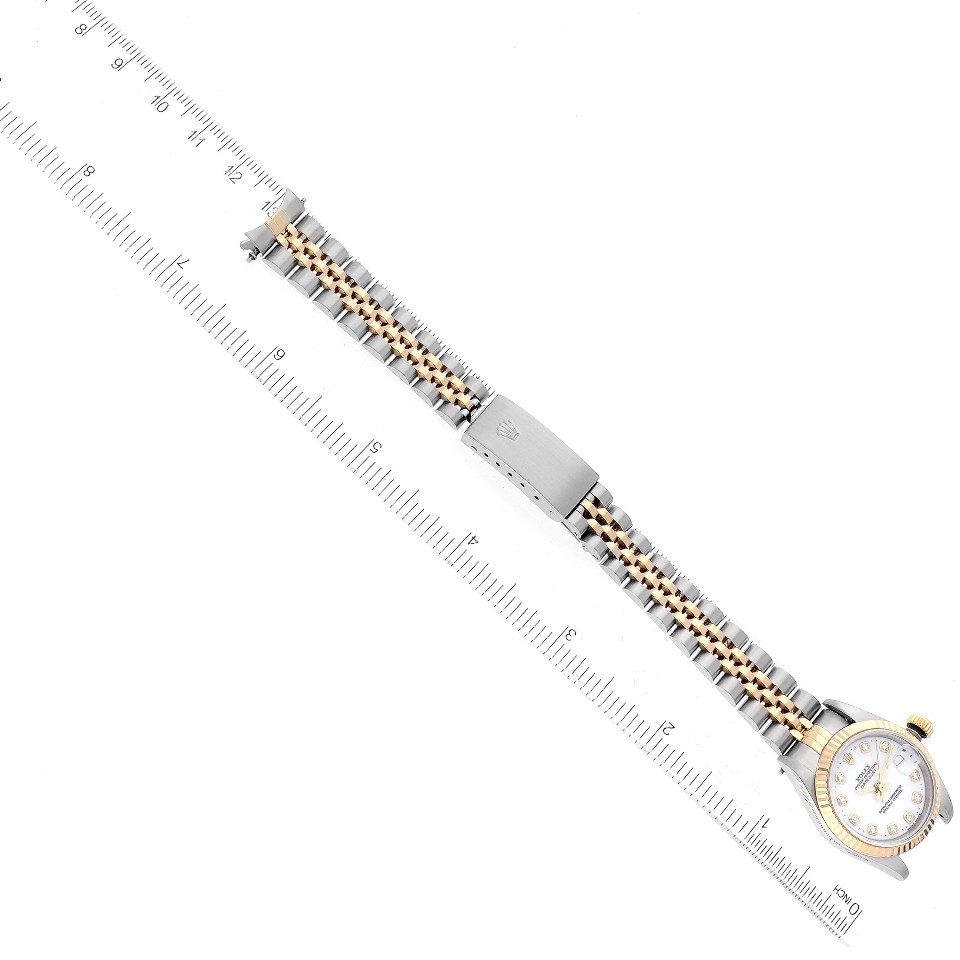 The Rolex Datejust 69173 Women's Steel and Gold (two tone) White Dial 69173 Women's Steel and Gold (two tone) White Dial watch is shown from a top-down angle, highlighting the full bracelet and clasp, with a ruler for scale.