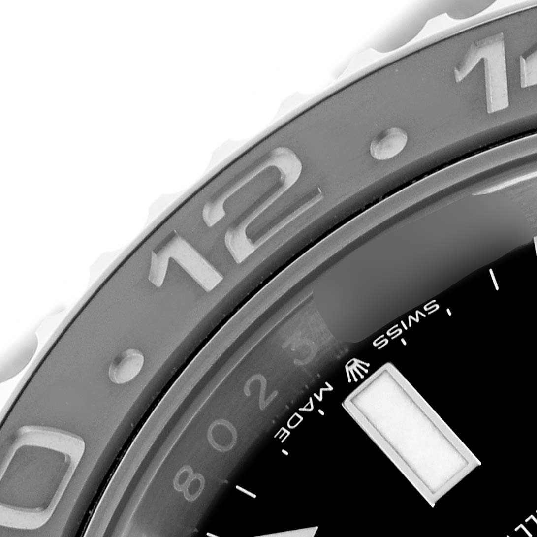 The image shows a close-up of the bezel and part of the dial of a Rolex GMT-Master 126710GRNR Men's Stainless Steel Black Dial 126710GRNR Men's Stainless Steel Black Dial watch, focusing on the 12-hour marker.