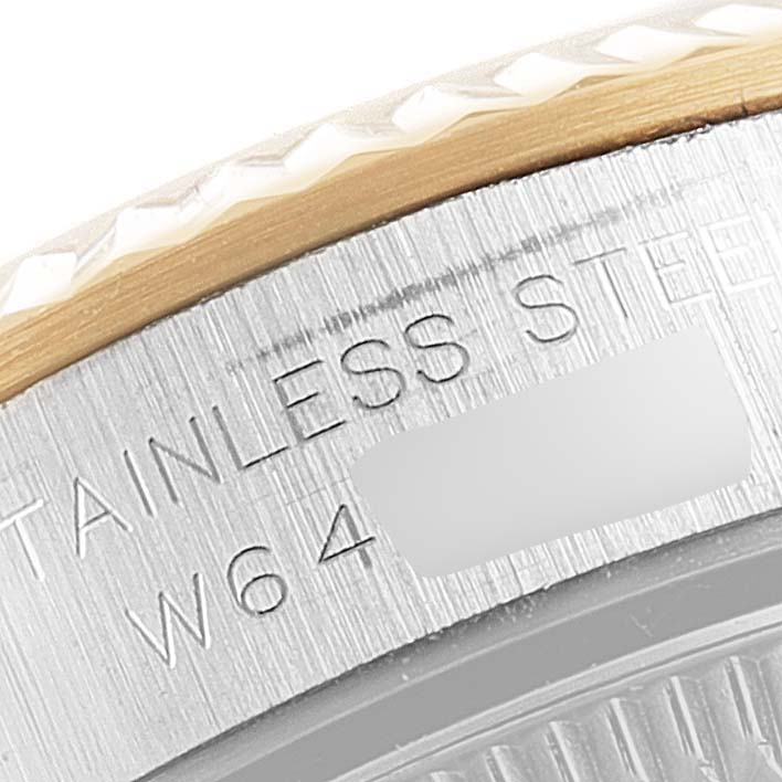 The image shows a close-up of the Rolex Oyster Perpetual 67193 Women's Steel and Gold (two tone) Black Dial 67193 Women's Steel and Gold (two tone) Black Dial's stainless steel case back with some engraved characters.