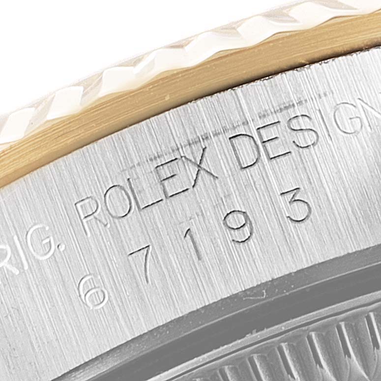 The image shows a close-up of the engraved case side of a Rolex Oyster Perpetual 67193 Women's Steel and Gold (two tone) Black Dial 67193 Women's Steel and Gold (two tone) Black Dial watch.