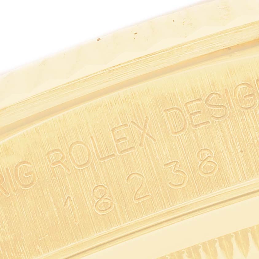 The image shows a close-up of the engraved bezel side of the Rolex President 18238 Men
s Yellow Gold Champagne Dial 18238 Men
s Yellow Gold Champagne Dial model, displaying text and numbers.