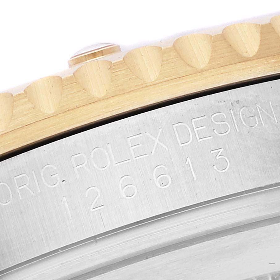 This close-up image shows the engraved edge of the bezel and case of a Submariner model by Rolex.