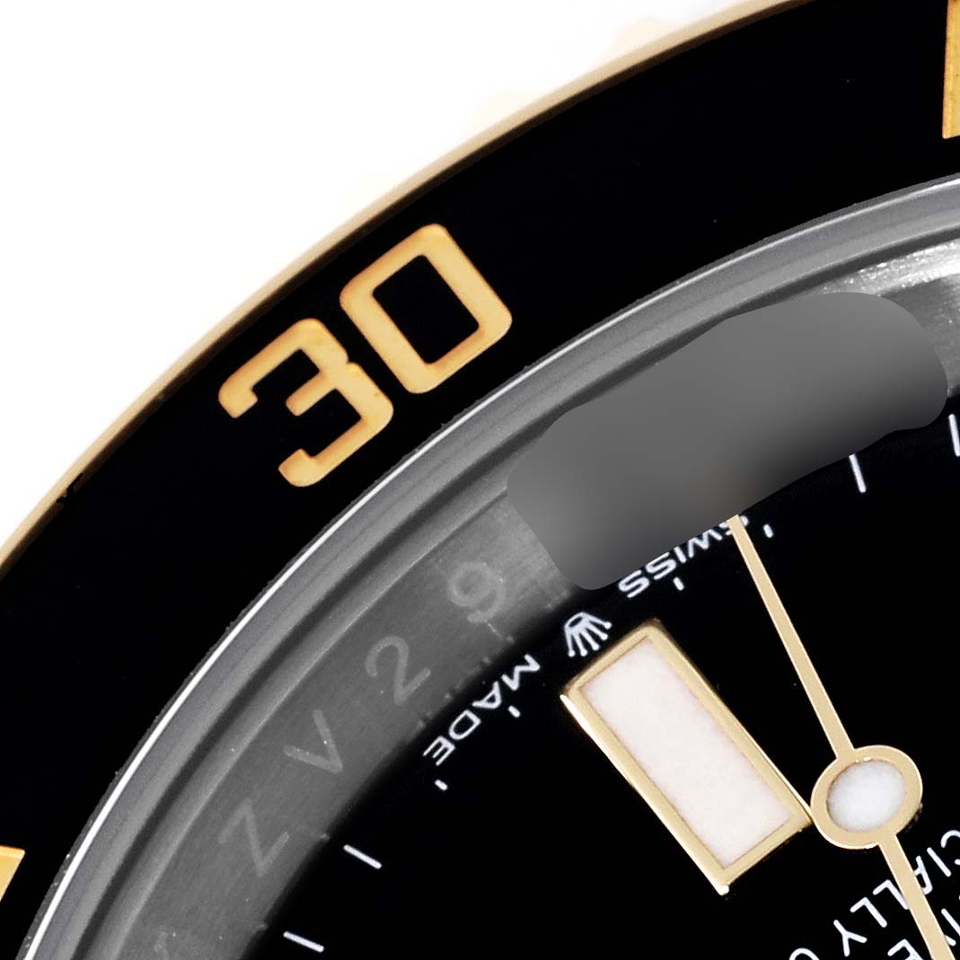 The image shows a close-up of the bezel and a portion of the dial of a Rolex Submariner 126613LN Men
s Steel and Gold (two tone) Black Dial 126613LN Men
s Steel and Gold (two tone) Black Dial watch.