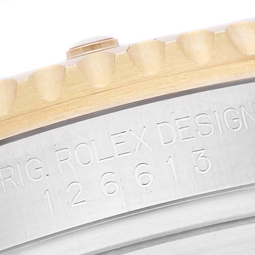 The image shows a close-up of the side engraving and bezel edge of a Rolex Submariner 126613LB Men
s Steel and Gold (two tone) Blue Dial 126613LB Men
s Steel and Gold (two tone) Blue Dial watch.