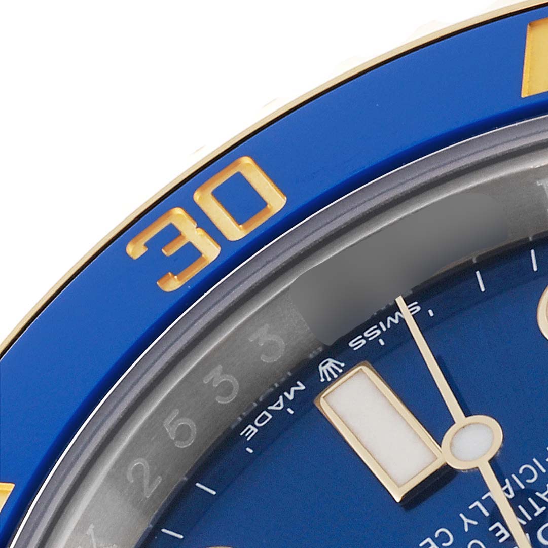 This close-up shows the blue bezel and part of the dial of a Rolex Submariner 126613LB Men
s Steel and Gold (two tone) Blue Dial 126613LB Men
s Steel and Gold (two tone) Blue Dial watch, highlighting the luminescent 30-minute mark.