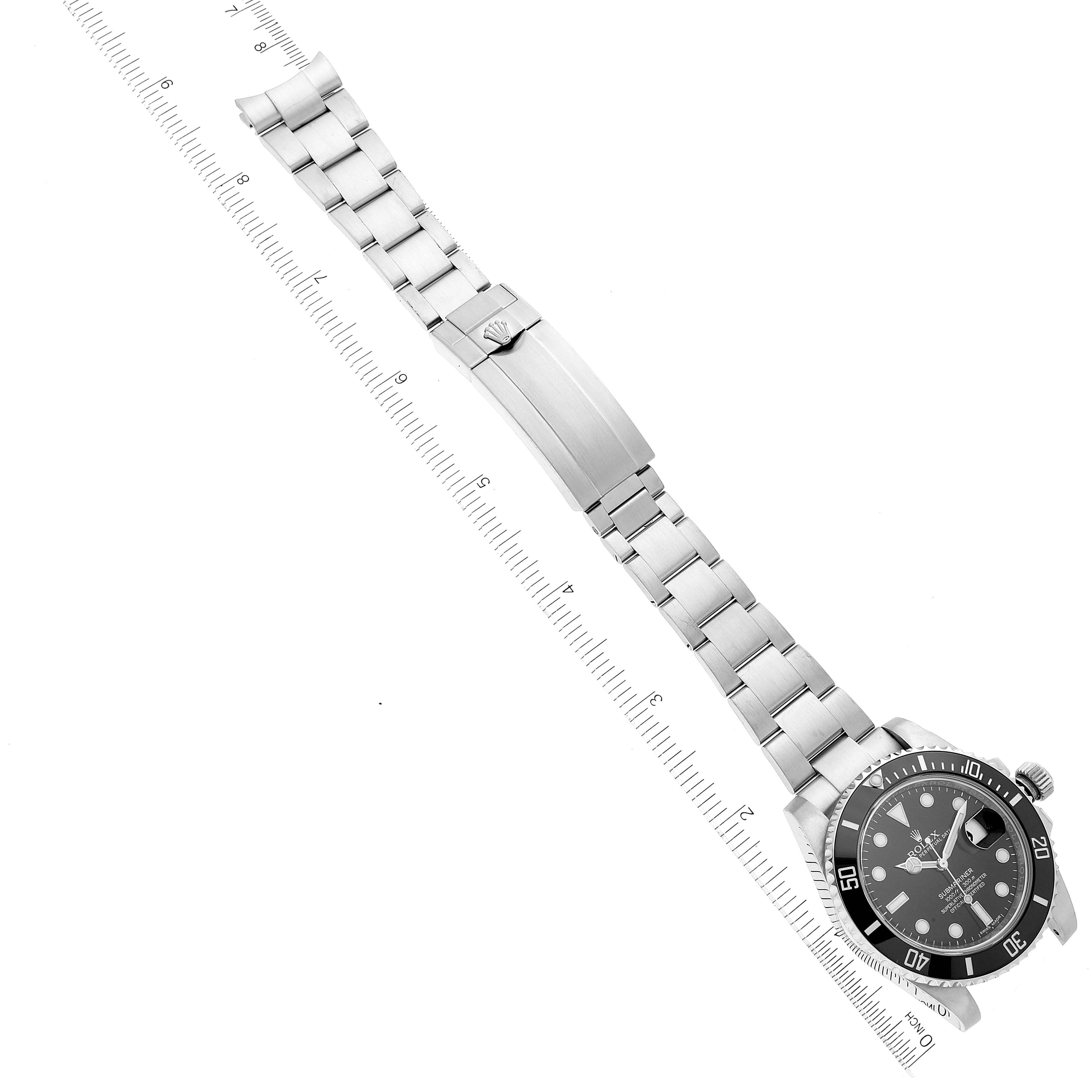 This image shows a top-down view of the Rolex Submariner 116610 Men's Stainless Steel Black Dial 116610 Men's Stainless Steel Black Dial watch, including the dial, bezel, bracelet, and clasp, alongside a ruler for measurement.