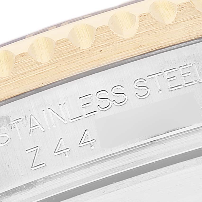 The image shows a close-up of the bezel and part of the casing with engravings of a Rolex Submariner 16613 Men's Steel and Gold (two tone) Blue Dial 16613 Men's Steel and Gold (two tone) Blue Dial watch.