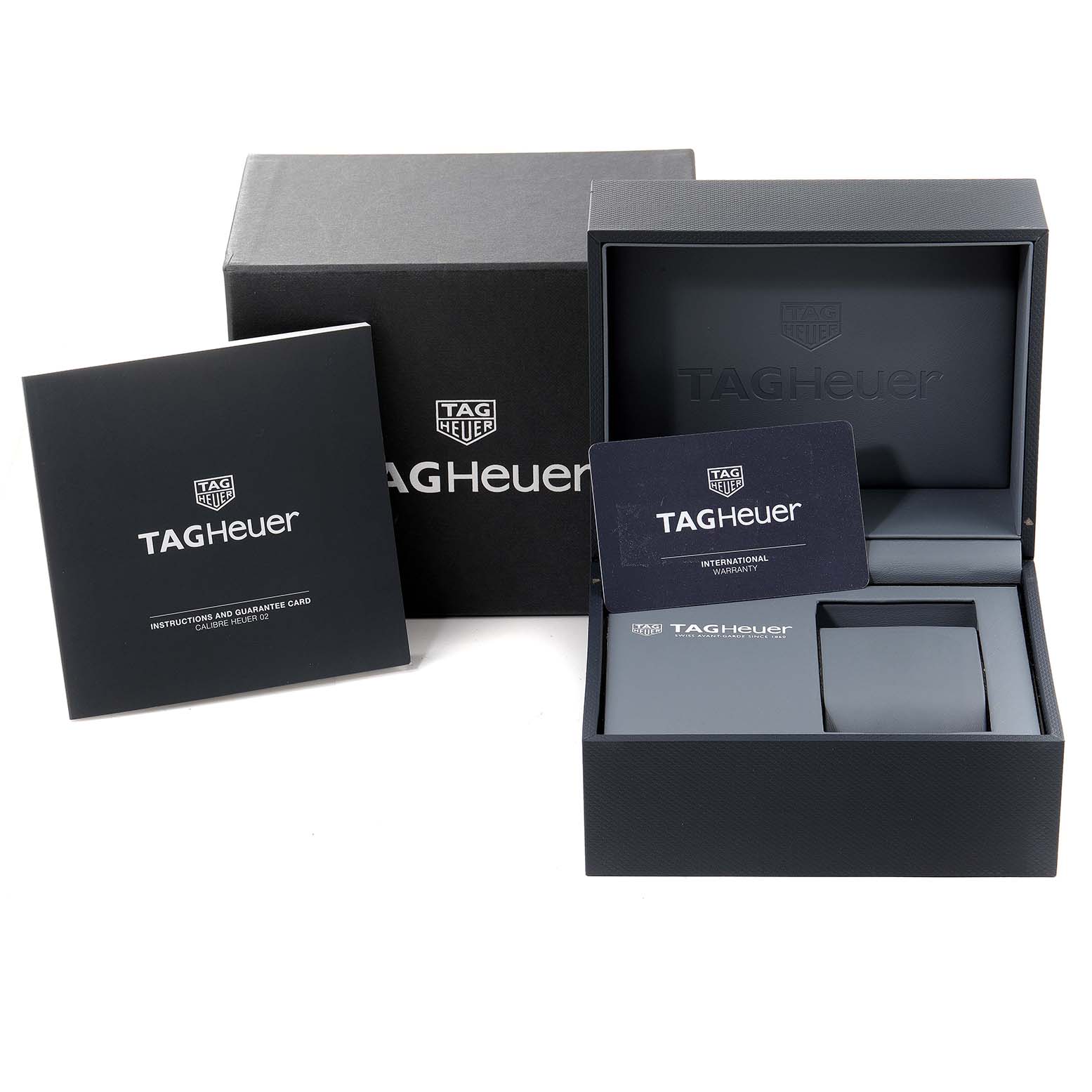 The image shows the packaging, booklet, cushion, and warranty card for a Tag Heuer Carrera watch.