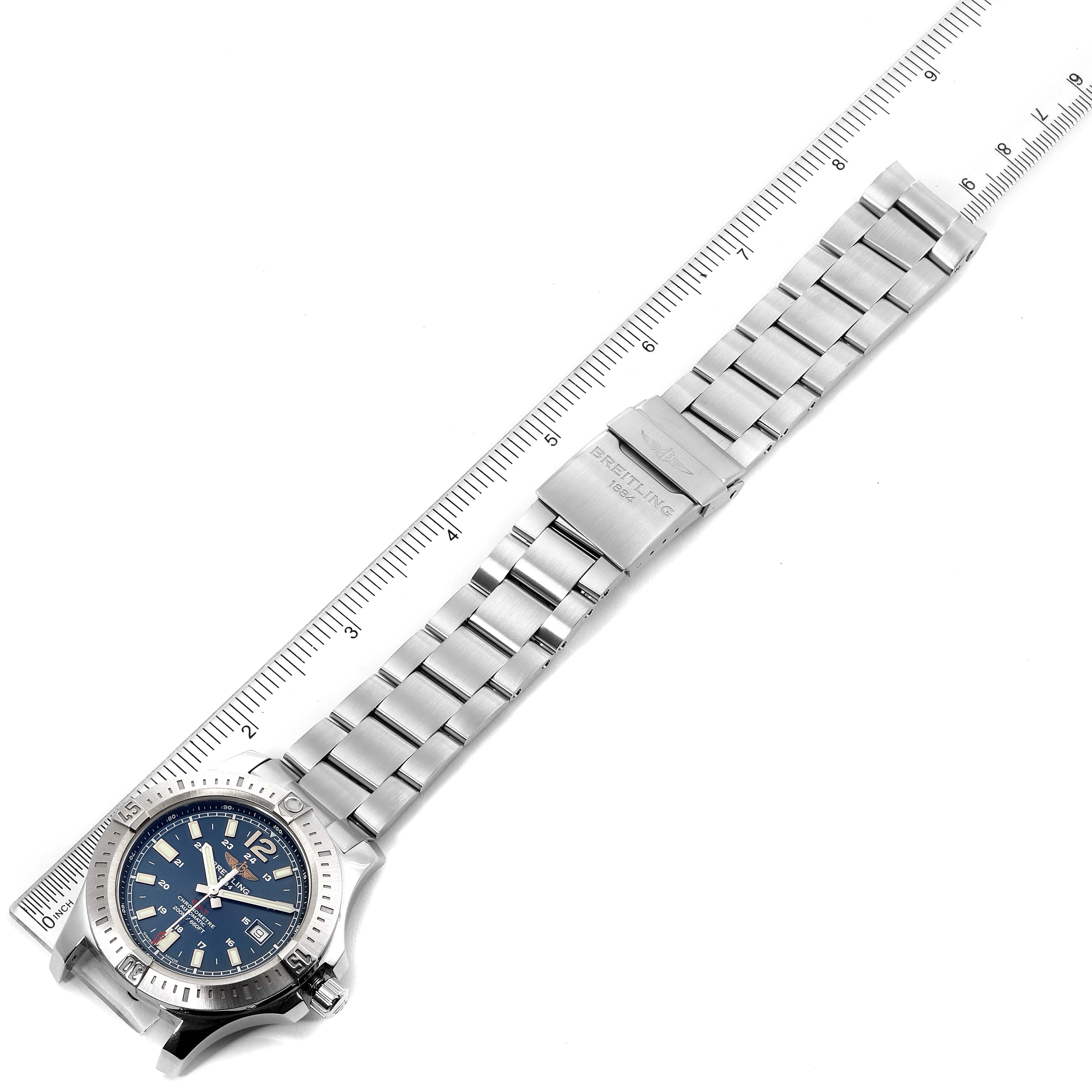 The image shows a top-down view of a Breitling Colt A17388 Men's Stainless Steel Blue Dial A17388 Men's Stainless Steel Blue Dial watch, including its face and metal bracelet alongside a ruler for measurement.