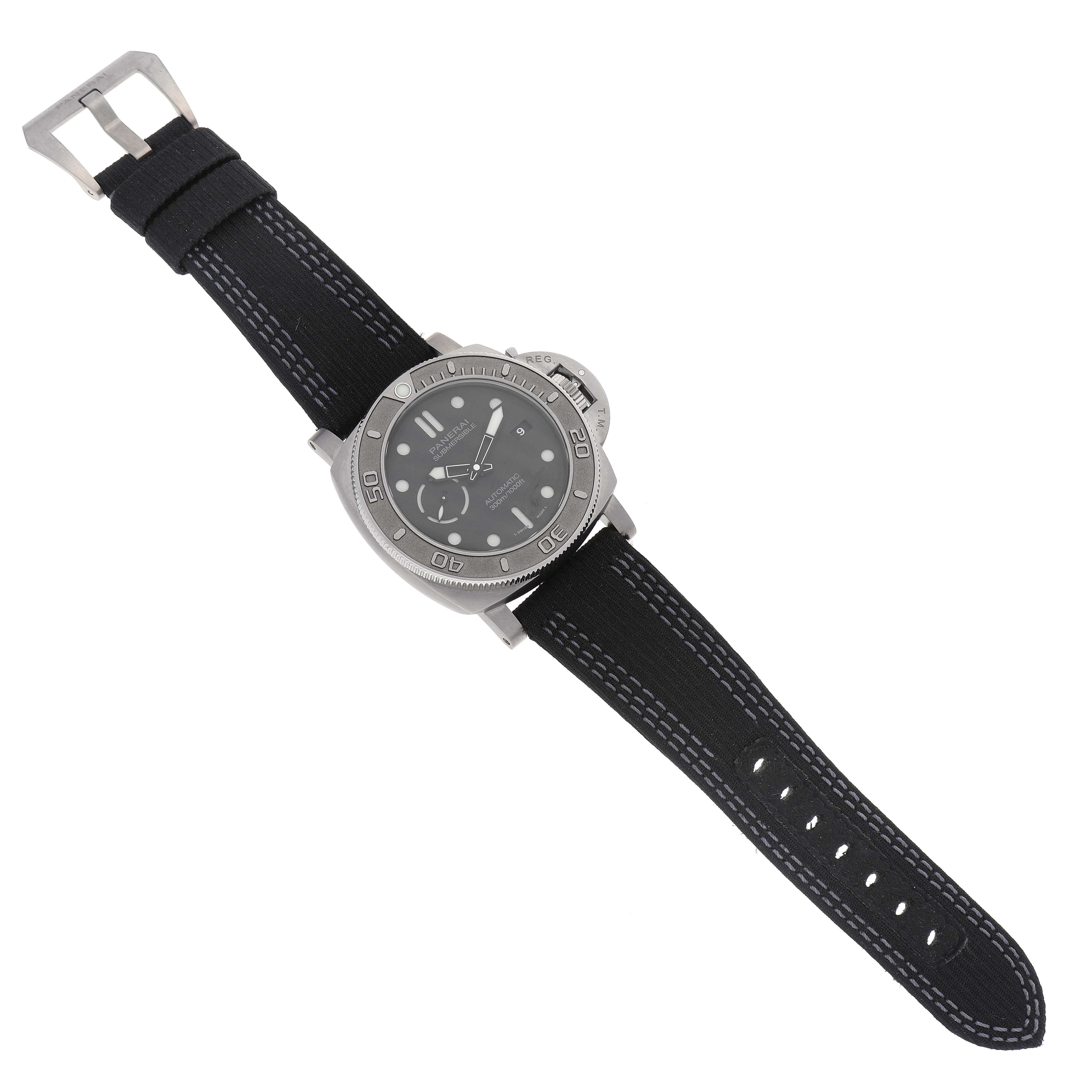 The Panerai Submersible PAM00984 Men's Titanium Black Dial PAM00984 Men's Titanium Black Dial watch is shown from a top-down angle, highlighting its face, bezel, strap, and buckle.