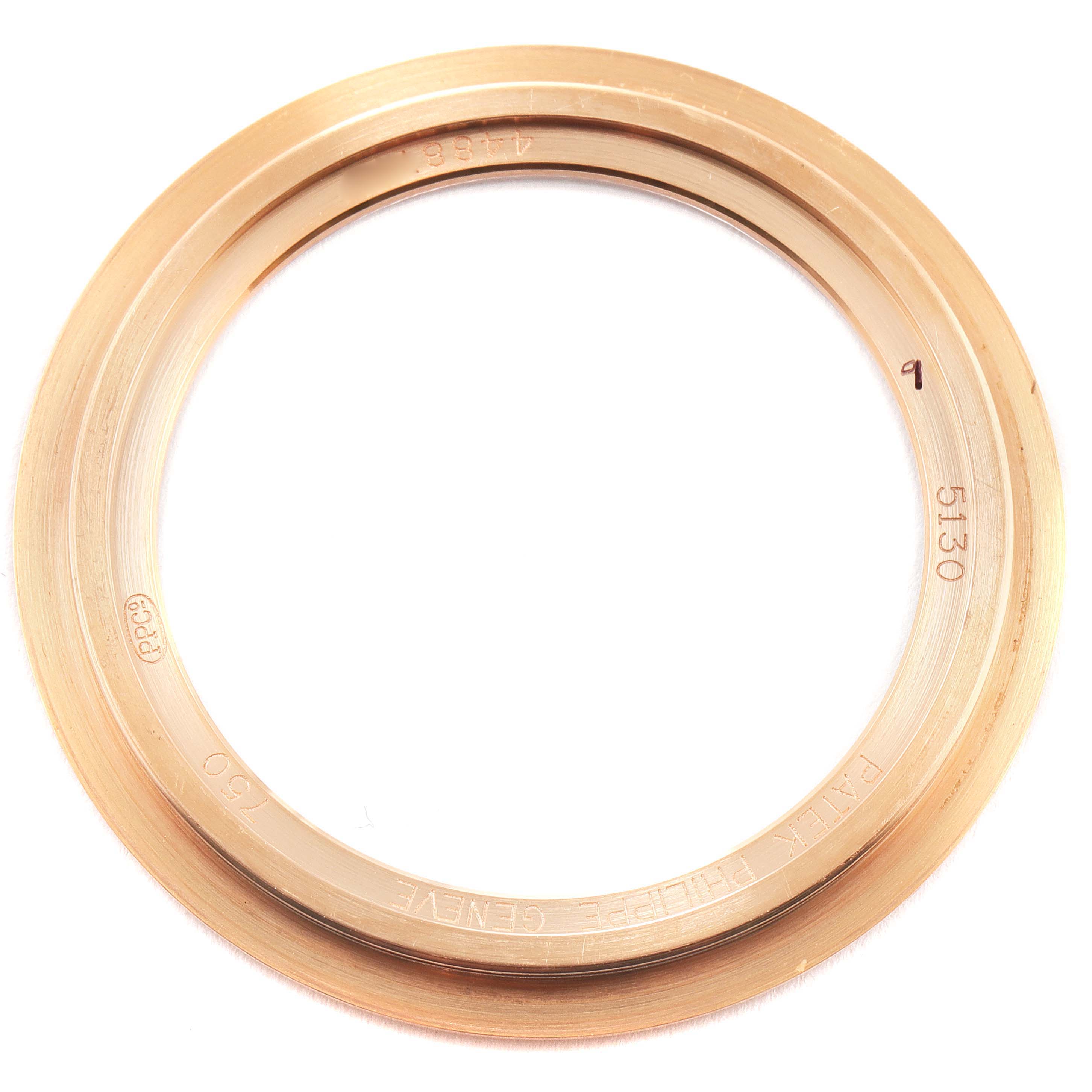 This image shows a gold bezel from a Patek Philippe Complications 5130R Men's Rose Gold Silver Dial 5130R Men's Rose Gold Silver Dial model watch viewed from above.