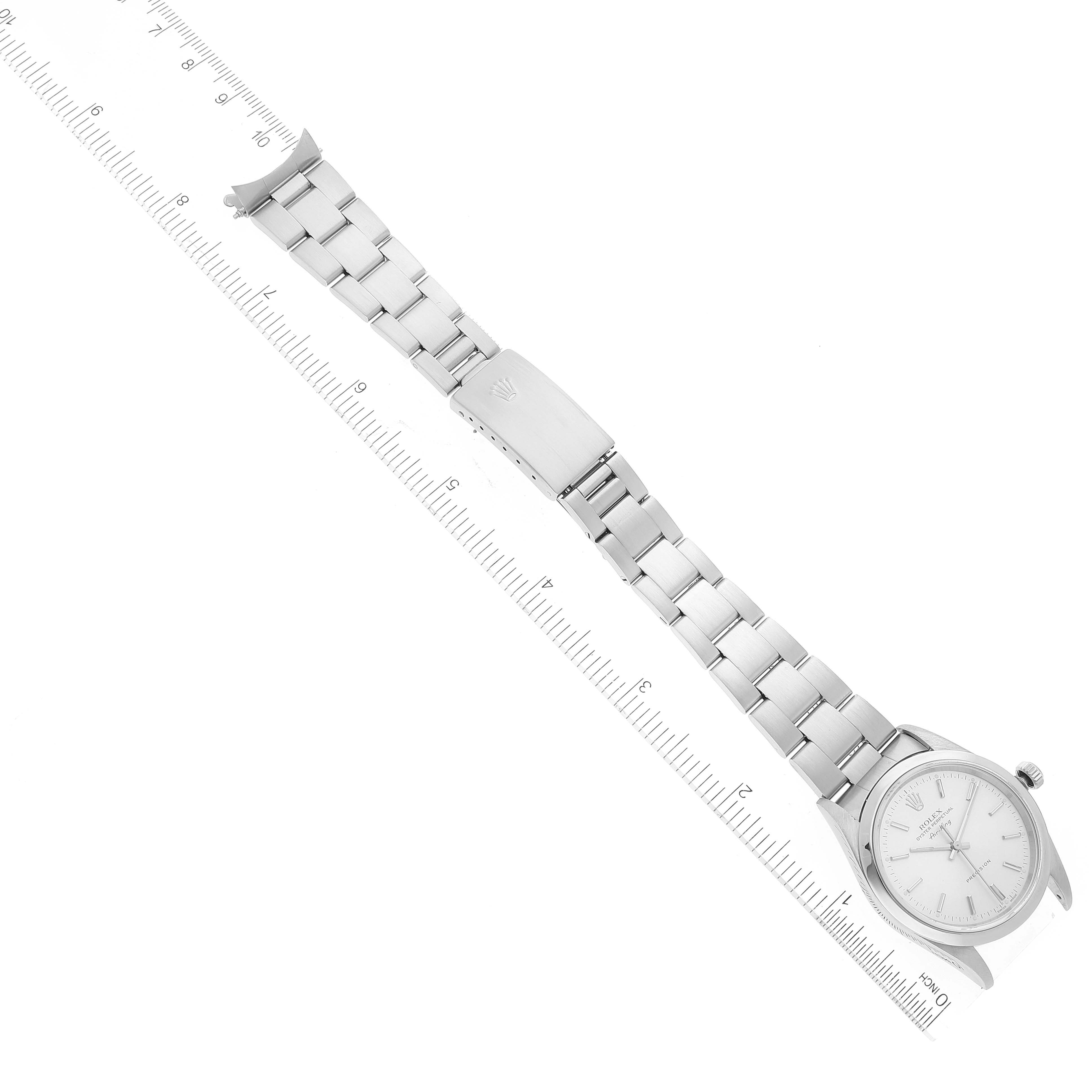 The Rolex Air-King 14000 Men's Stainless Steel Silver Dial 14000 Men's Stainless Steel Silver Dial watch is shown laid flat; displaying the face, band, and clasp next to a measuring ruler.
