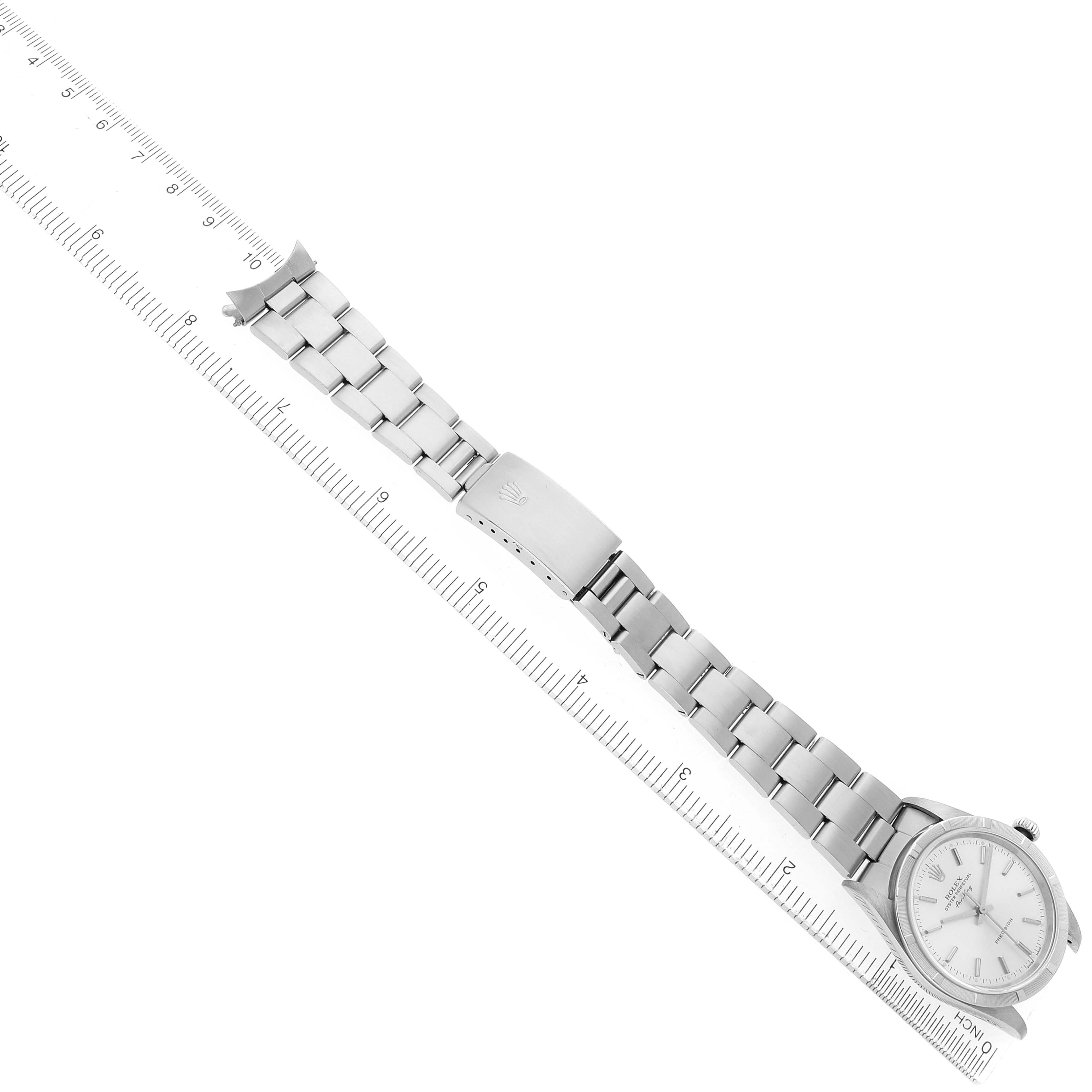The Rolex Air-King 14010 Men's Stainless Steel Silver Dial watch is positioned diagonally, showcasing its full bracelet and clasp alongside a ruler for scale.