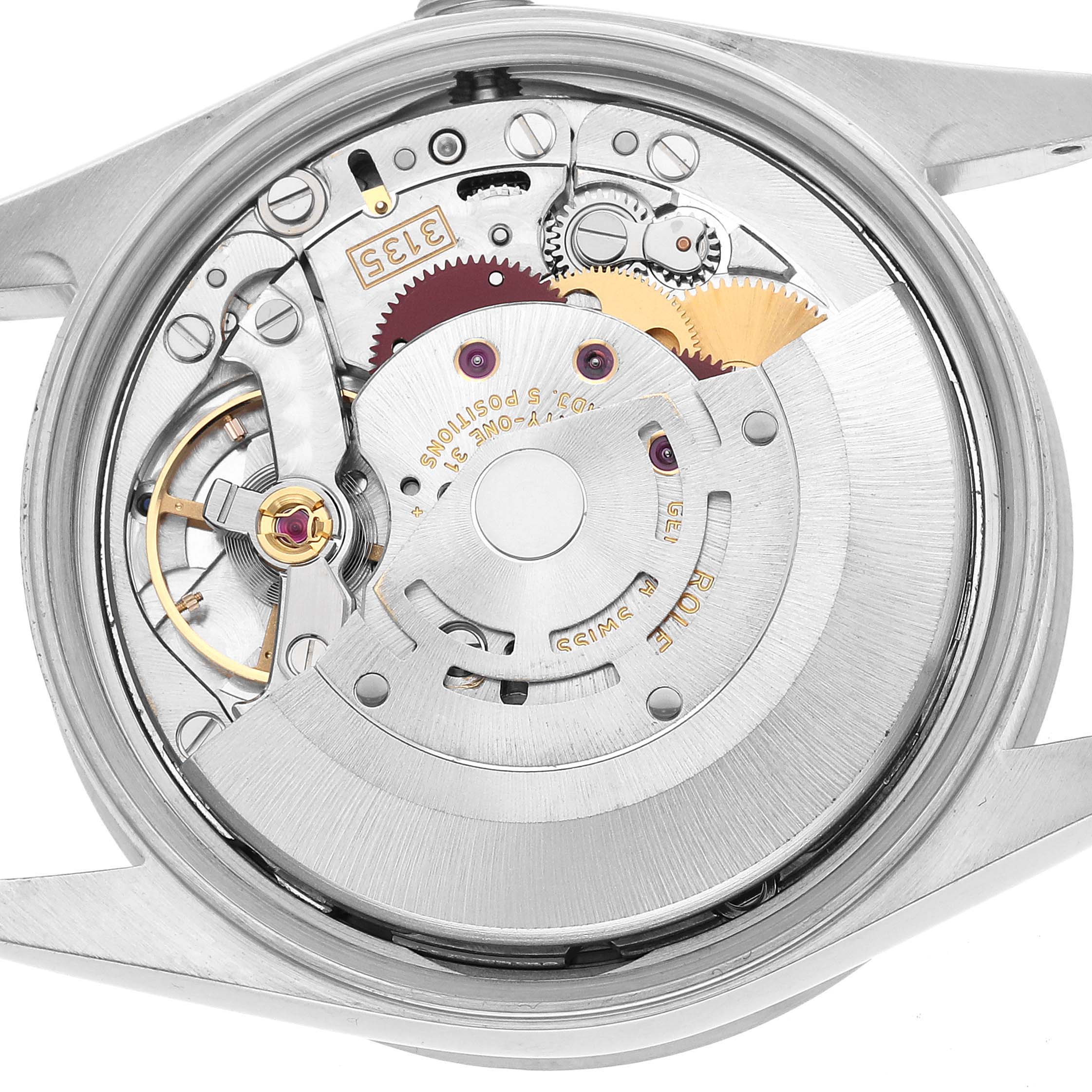 The image shows the movement of a Rolex Date 15210 Men's Stainless Steel Silver Dial watch, focusing on the rotor and intricate gear components.
