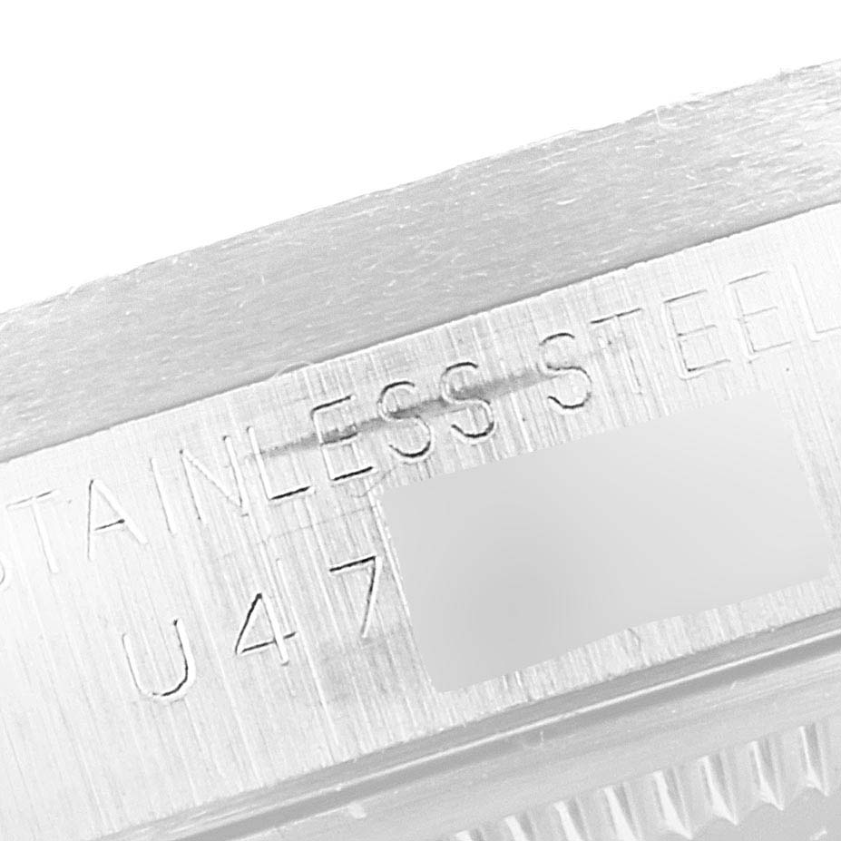 The image shows a close-up angle of the side of a Rolex Date 15210 Men's Stainless Steel Silver Dial 15210 Men's Stainless Steel Silver Dial model, highlighting the stainless steel marking and part of the watch's serial number.