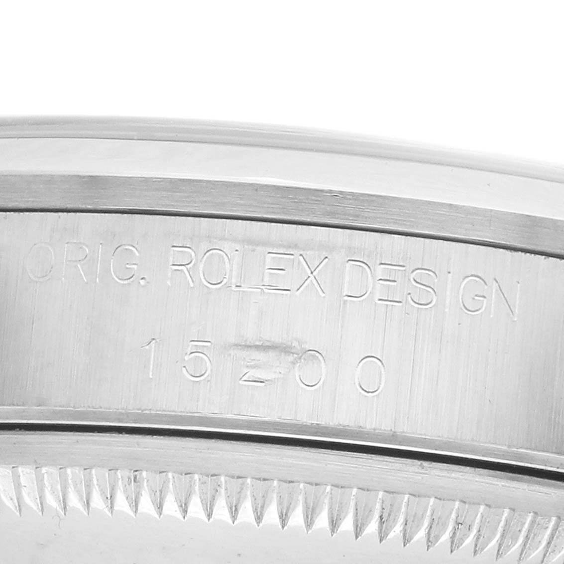 The image shows a close-up of the side of a Rolex Date 15200 Men's Stainless Steel Silver Dial watch case with engraved model numbers and design details.