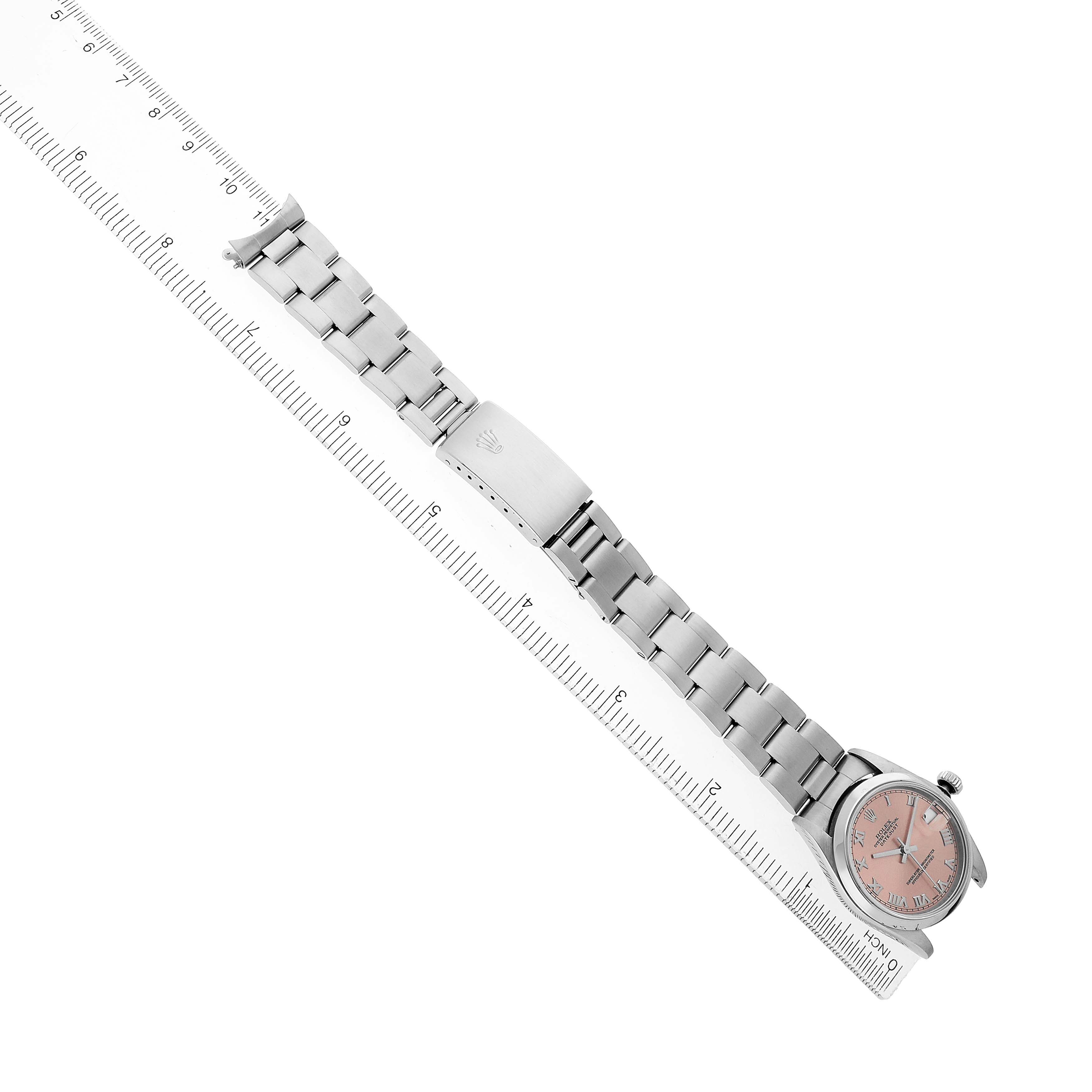 The Mid-Size Rolex is shown from above, displaying the watch face, bracelet, and clasp alongside a ruler.